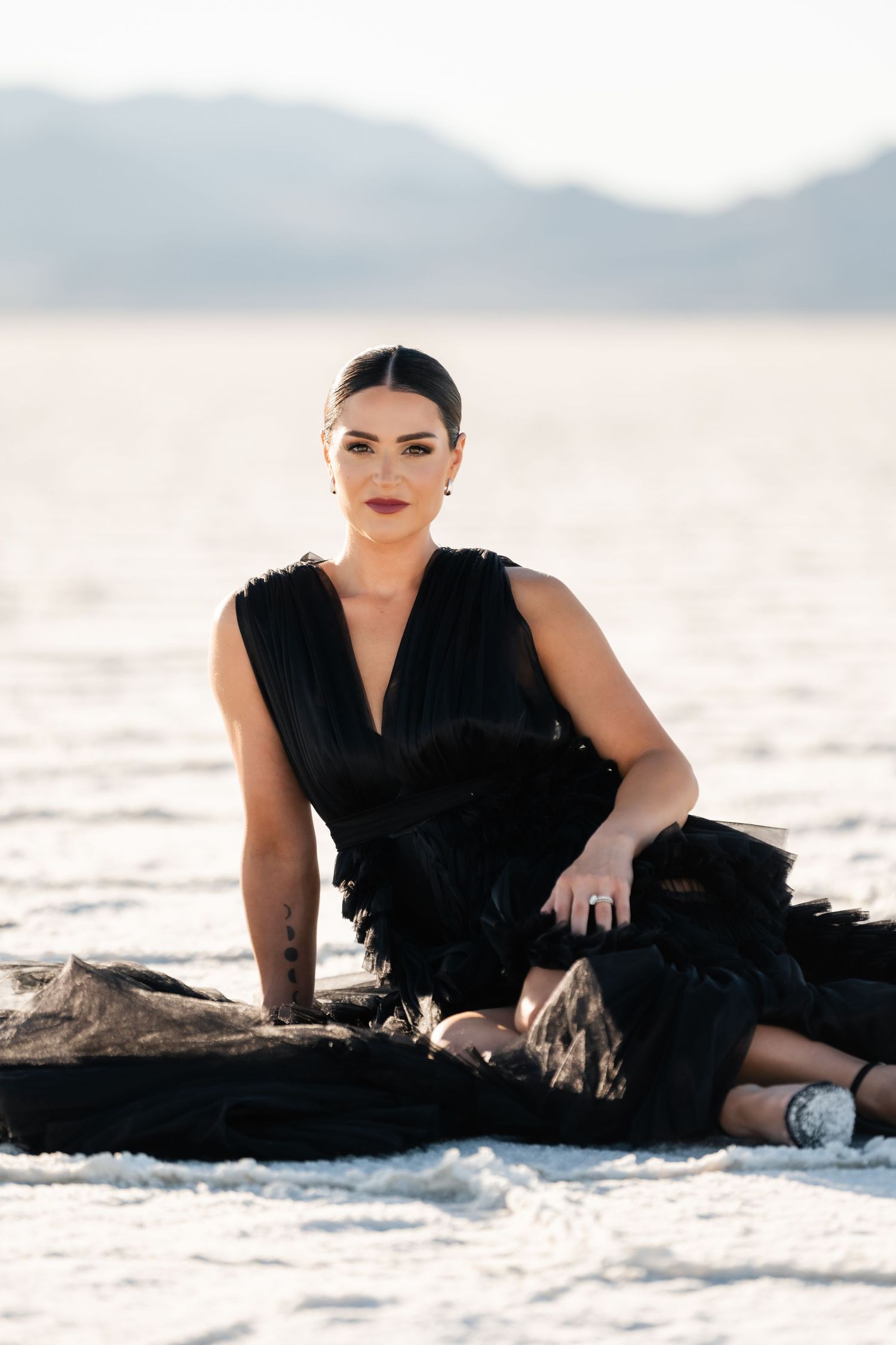 Salt Flats Photographer. Elegant fashion portrait on white salt flats featuring black formal dress and dramatic makeup.