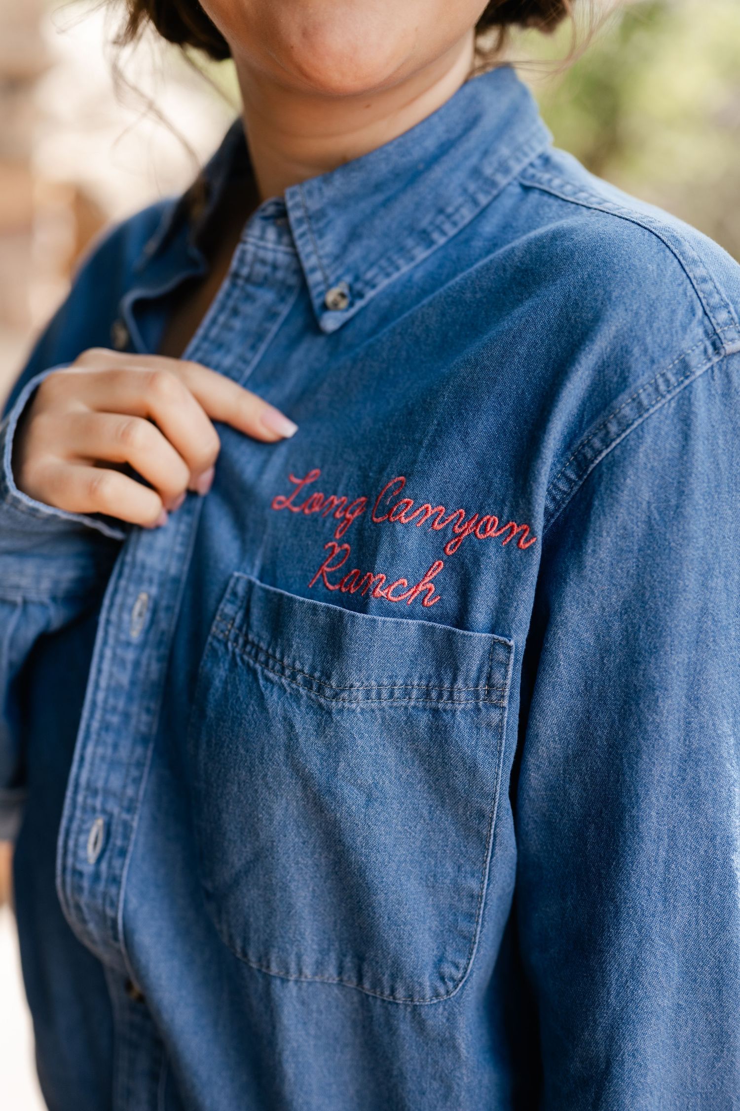 Close-up shots of denim shirts with red embroidered text details on the pockets.