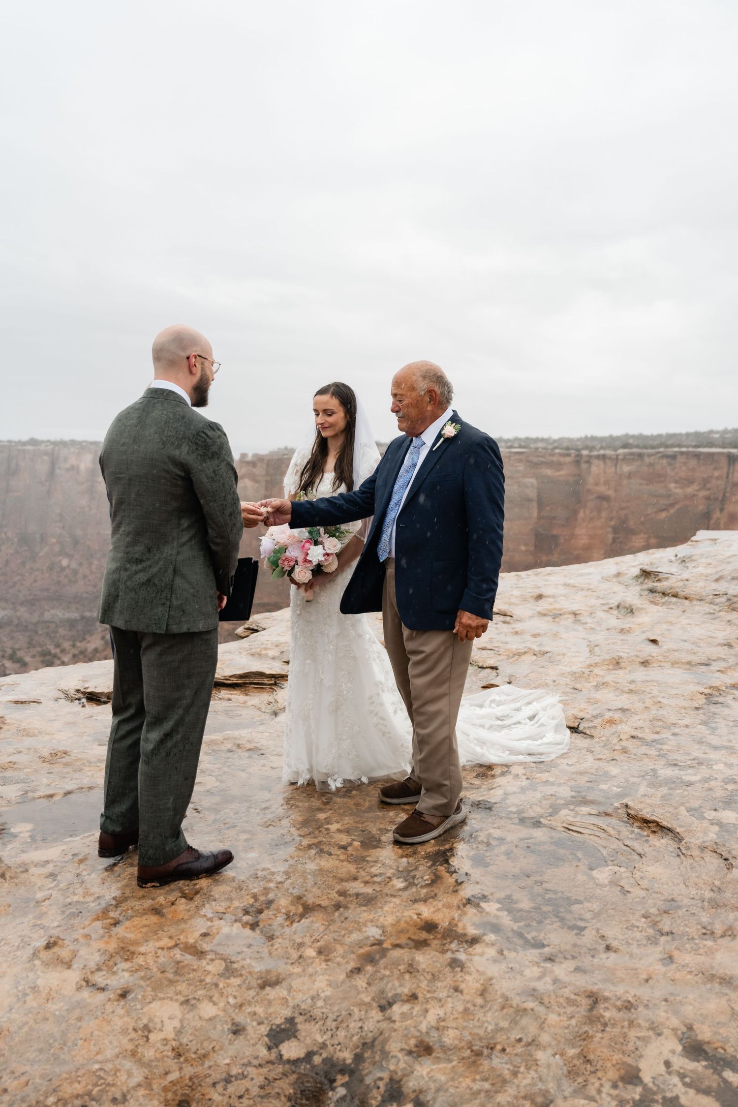 Intimate wedding ceremony unfolds on the rim of a majestic desert canyon with dramatic rock formations.