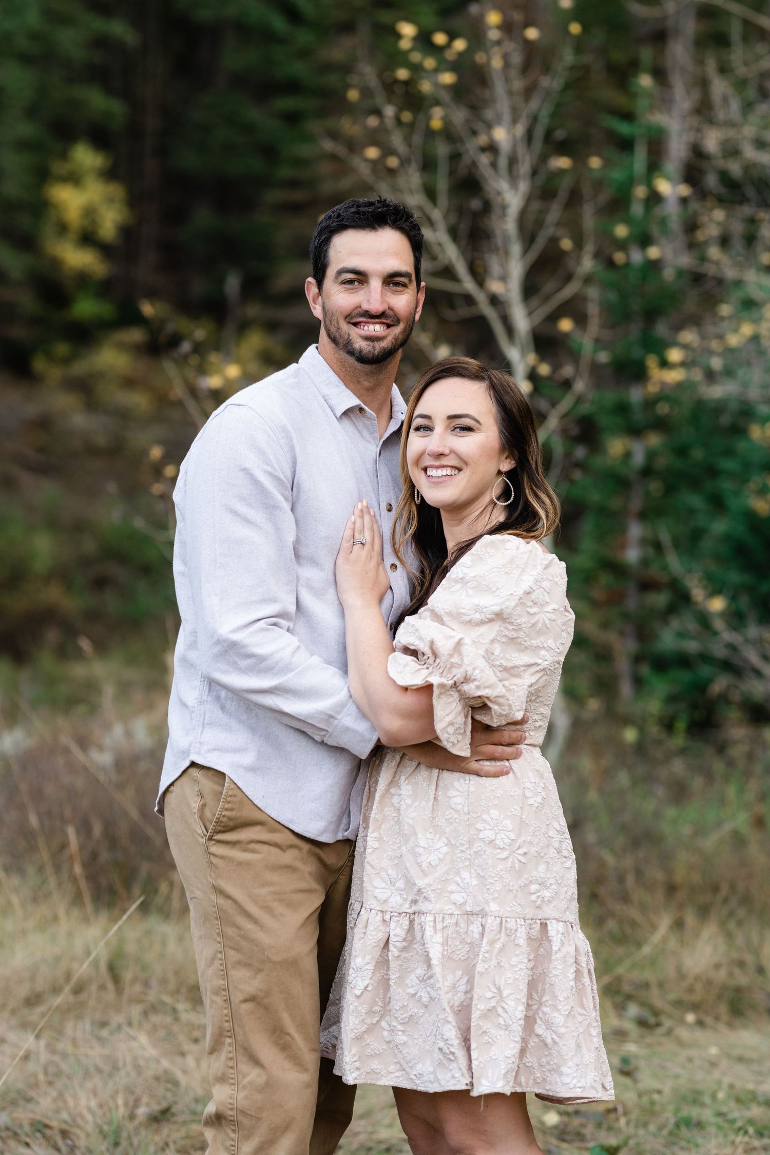Couple shares joyful moments together in an autumn mountain setting with golden light.