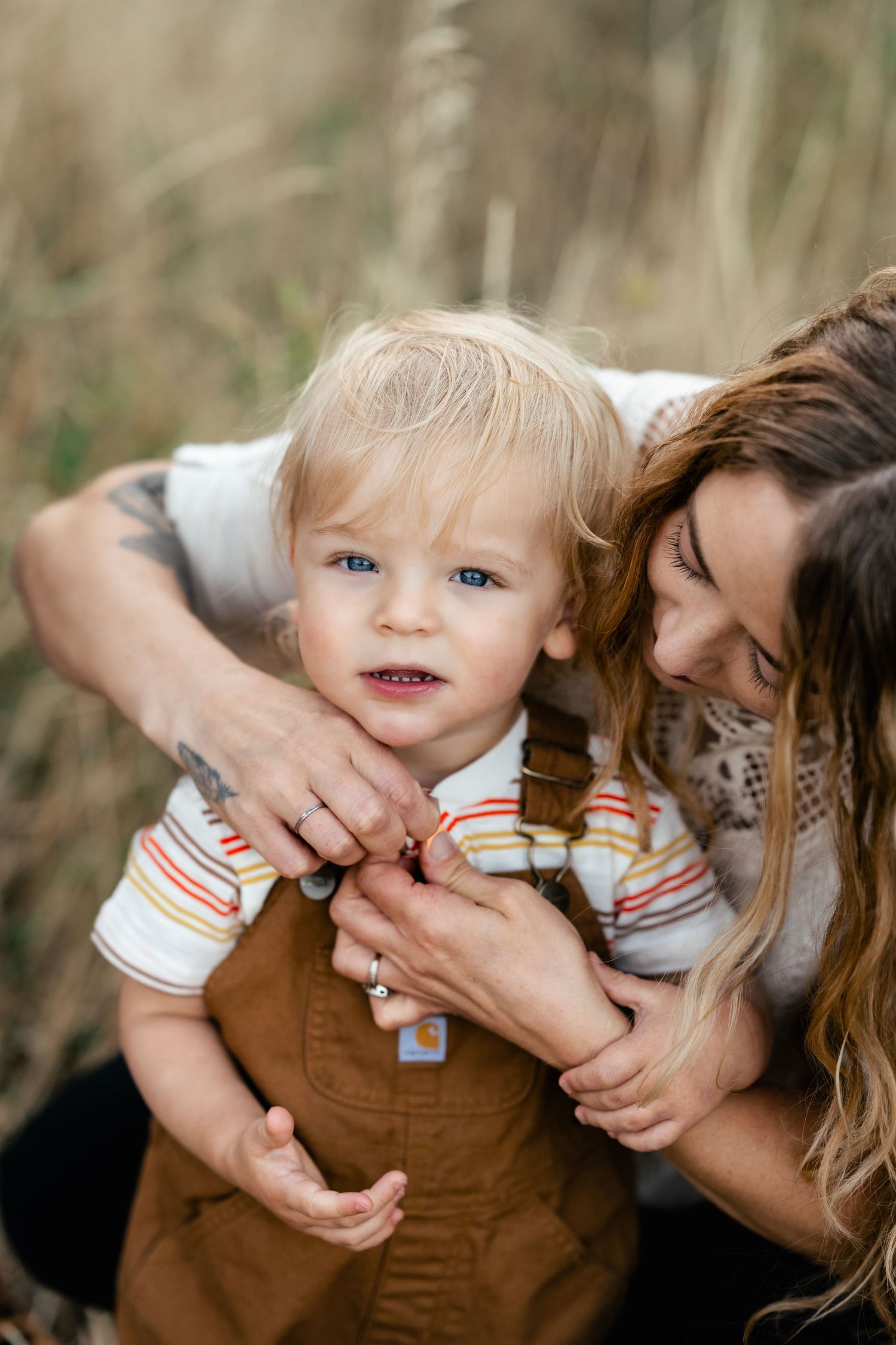 Series of close-up photos showing tender moments between a child in brown overalls and someone holding them.