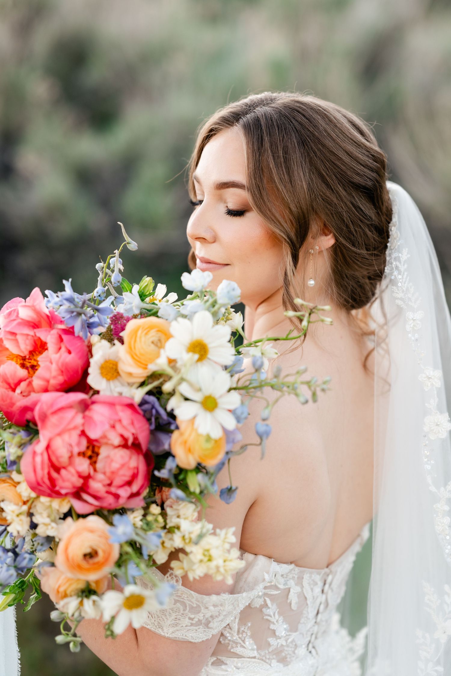 Beautiful bridal portrait series featuring a colorful spring bouquet with coral peonies, daisies and delicate lace veil details.