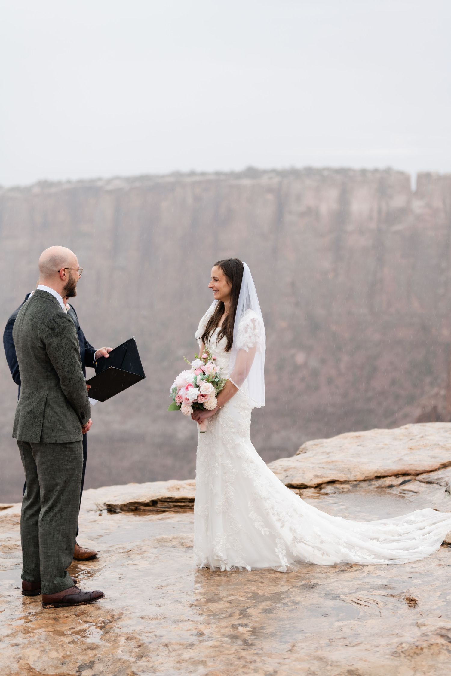 Wedding ceremony photos taken on a scenic desert cliff overlooking canyon views.