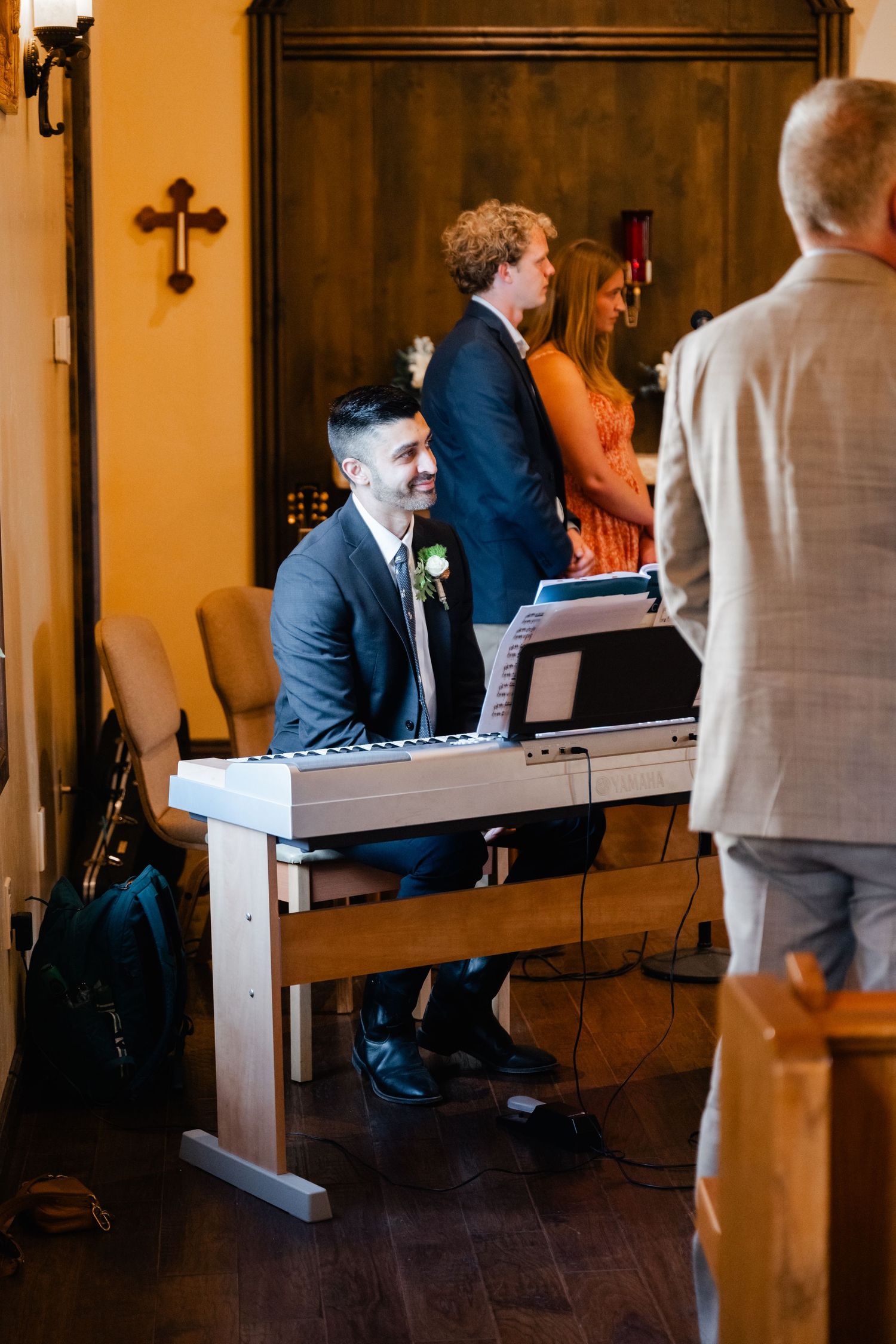Musicians perform at a wedding ceremony in a warmly lit church setting.