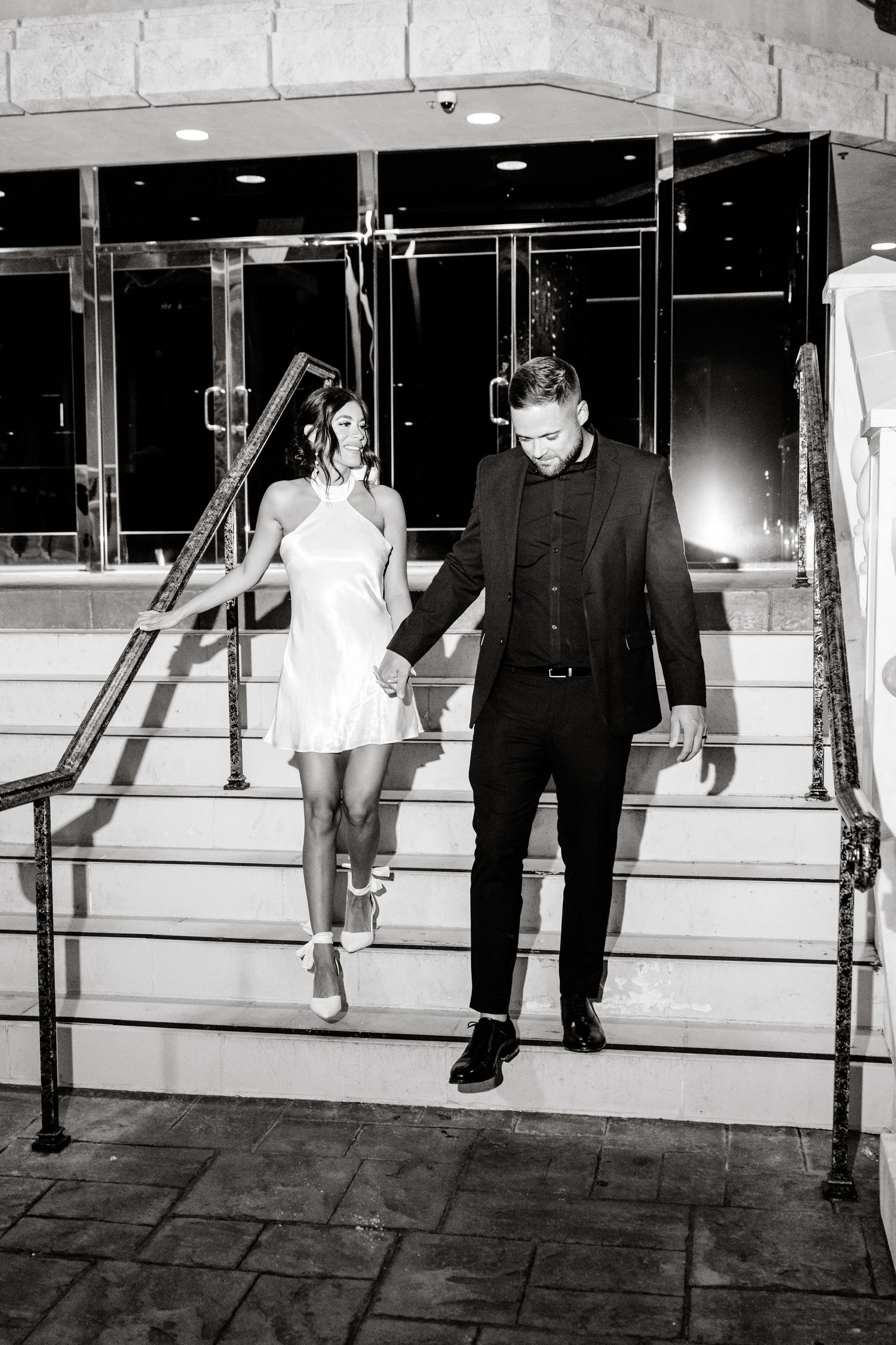 A black and white photo series showing legs and feet walking past a mirrored wall in a dance or ballet studio.