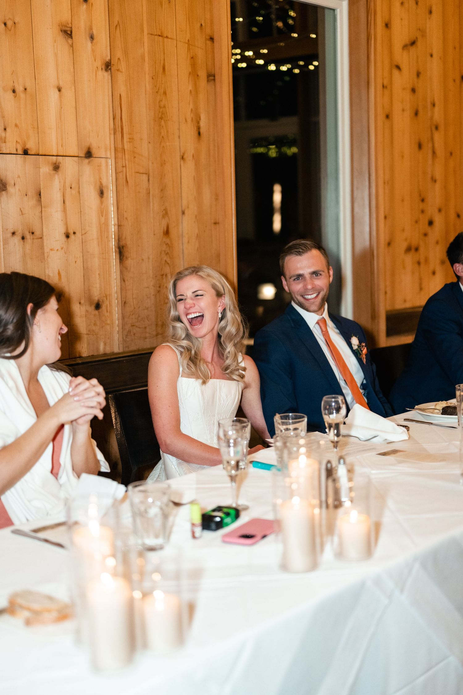 Wedding reception dinner with guests enjoying conversation at candle-lit table. Park City Wedding Photographer. Utah Wedding Photographer.