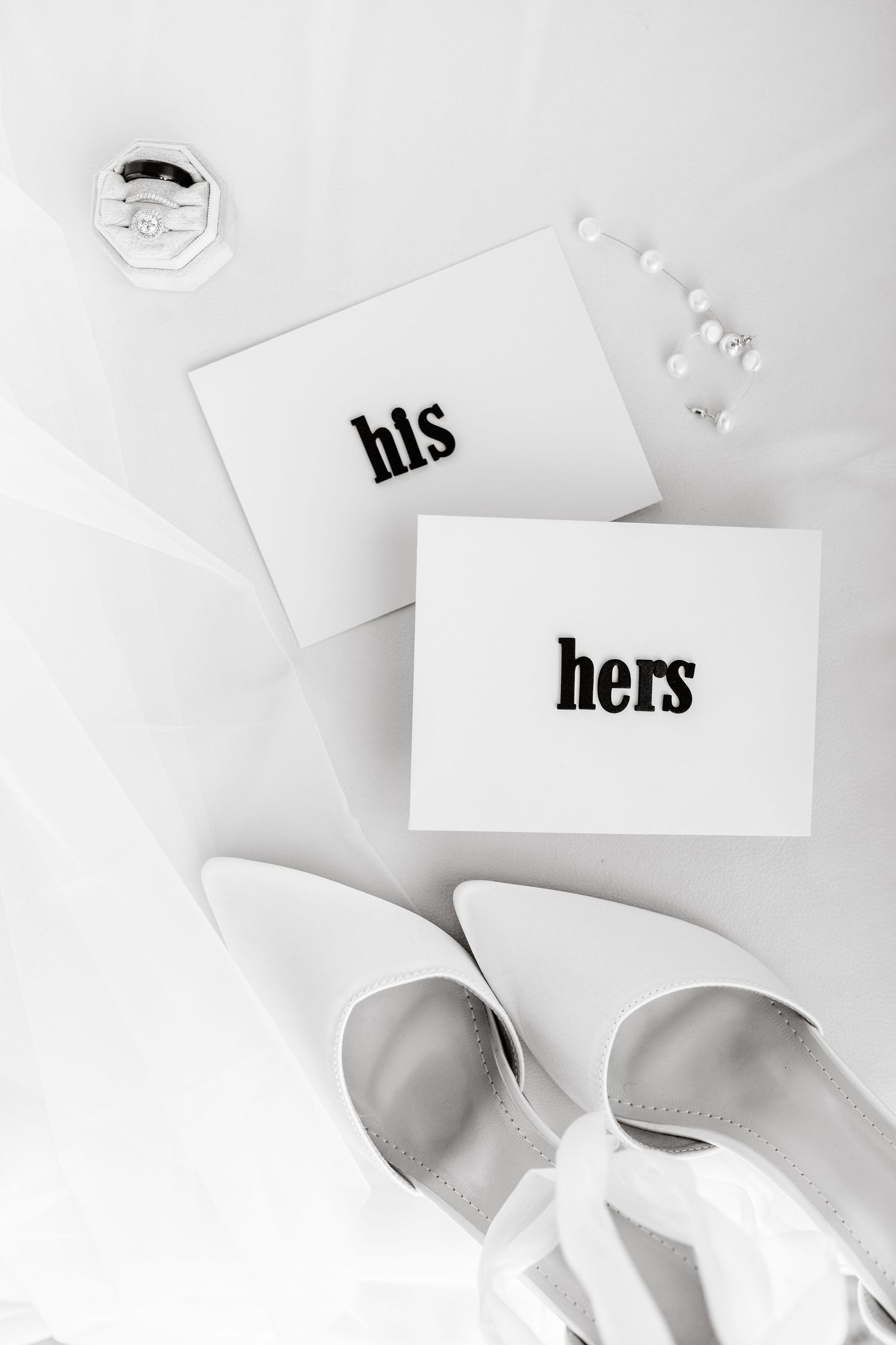 White cards with 'his' and 'hers' text displayed on a light background.