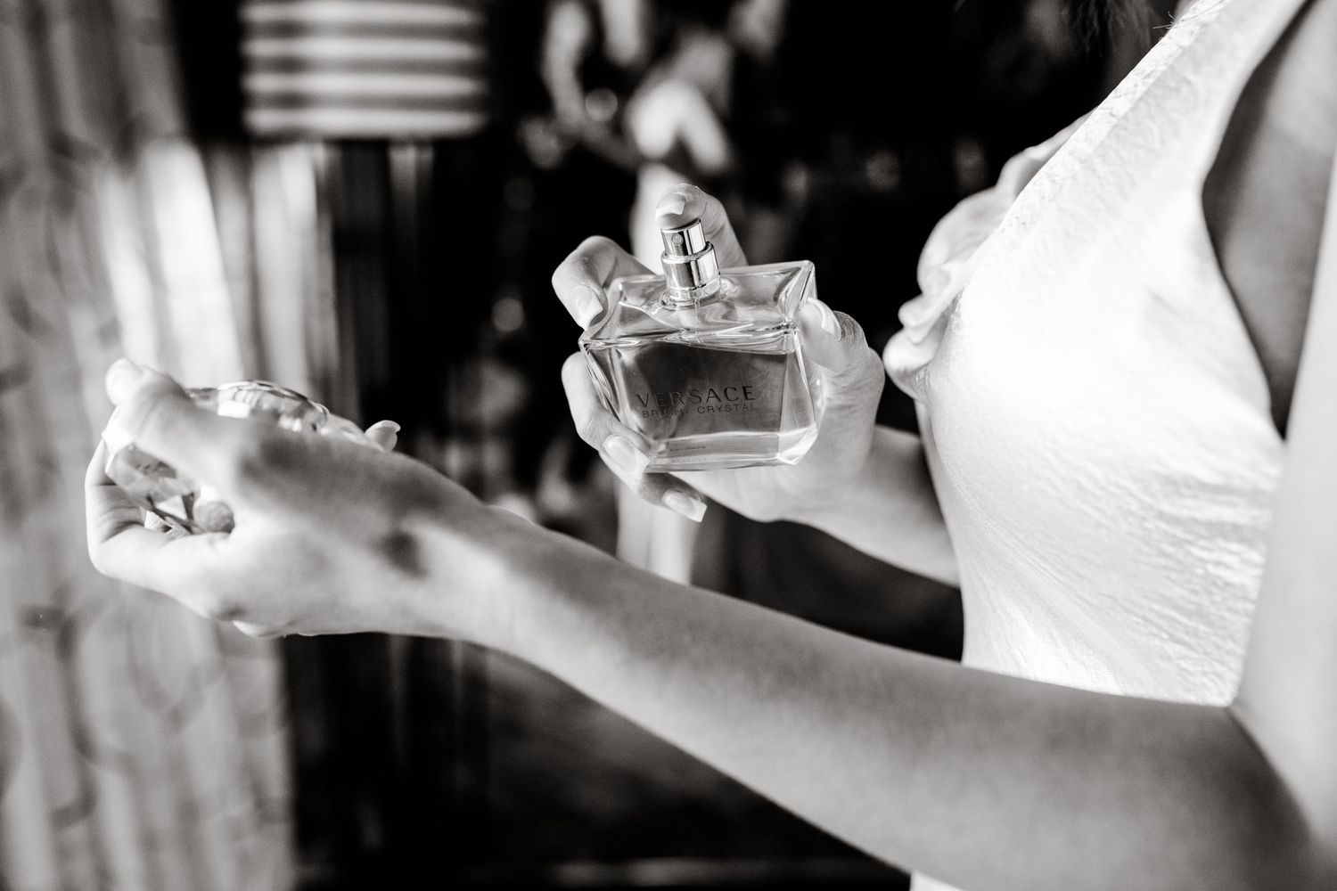 Black and white image of wedding guests raising champagne glasses in celebration.