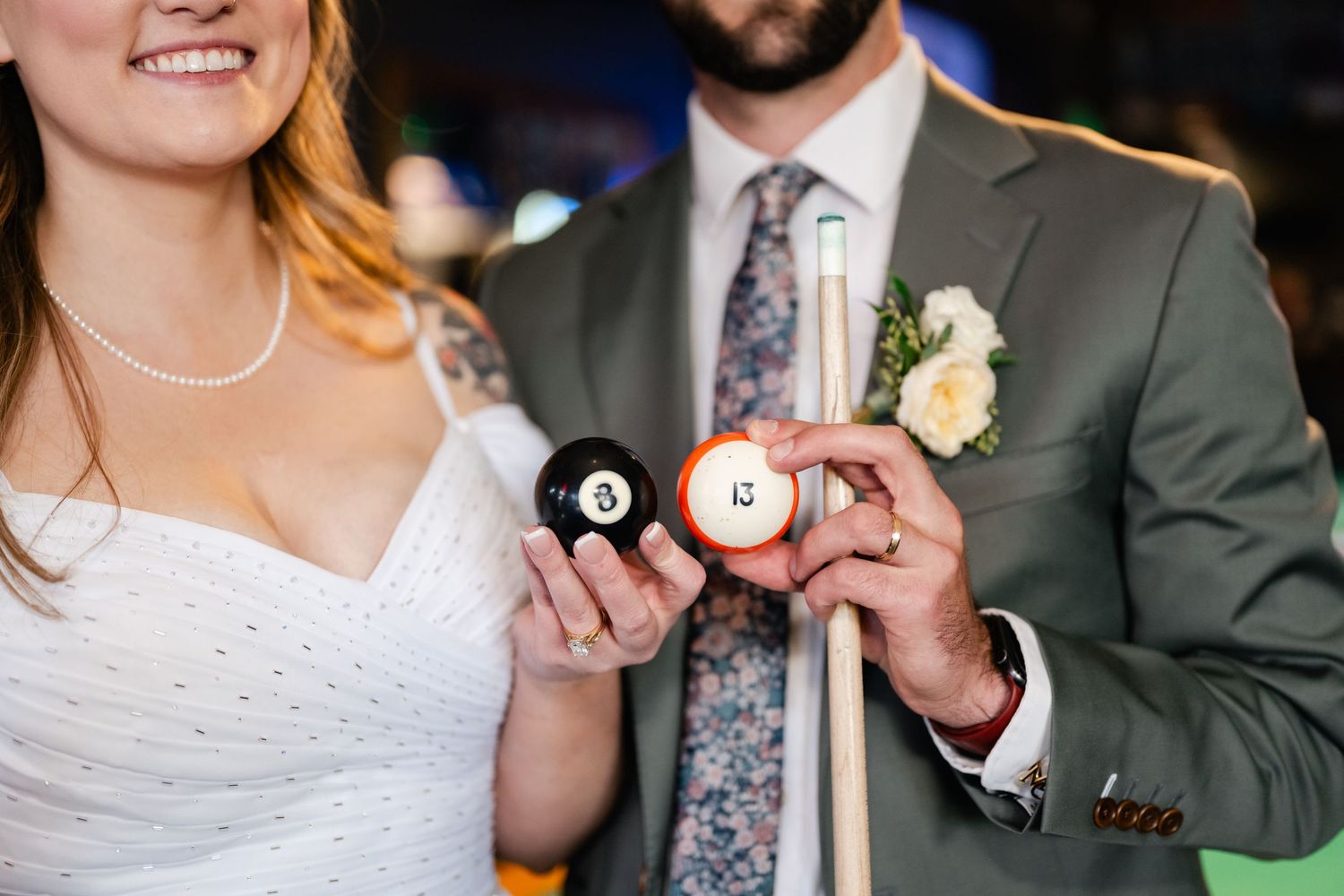 Wedding couple posing together in a casual bar setting with pool tables.