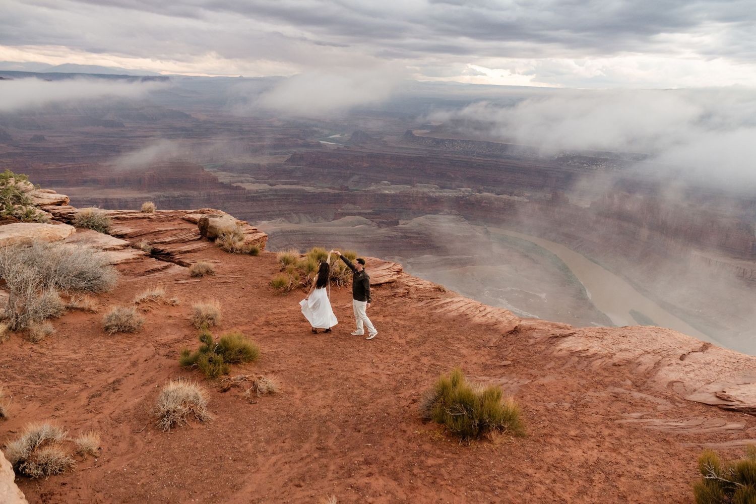 Scenic overlook of vast desert canyons with dramatic cloudy skies at Canyonlands National Park.