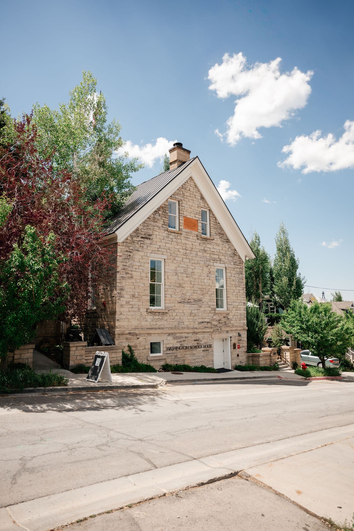 Front view of  the Washington School House Hotel. A historic stone building with a gabled roof and chimney.