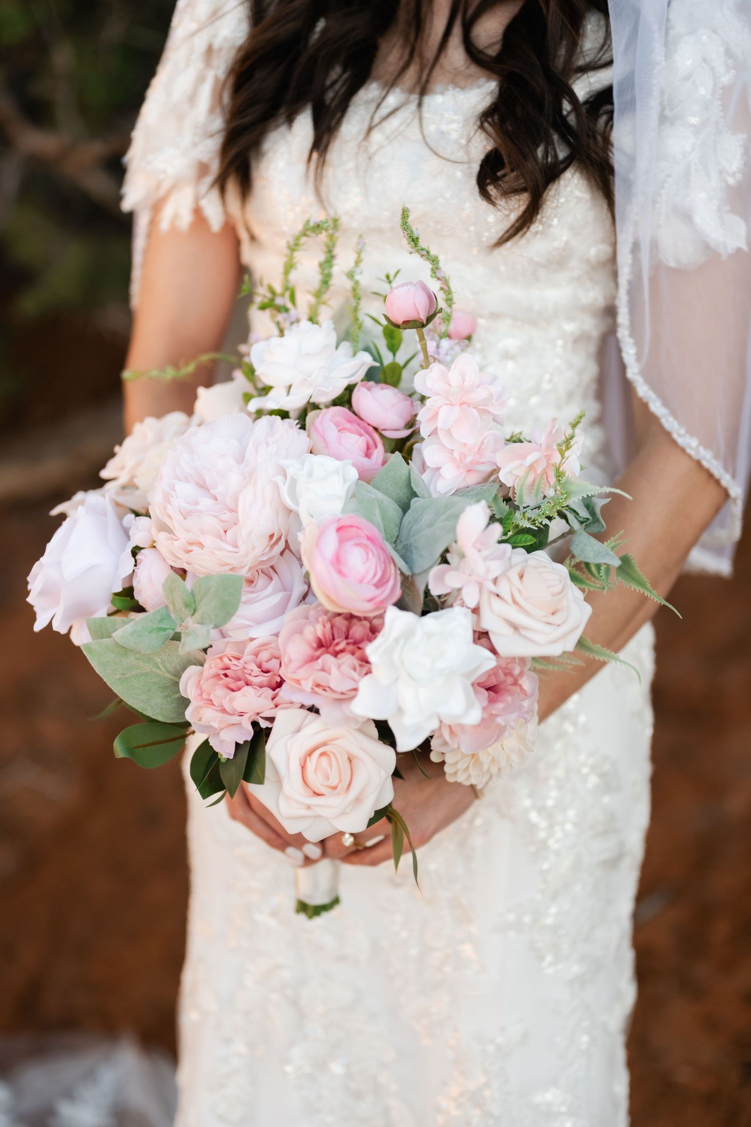 A delicate bridal bouquet featuring soft pink roses and white flowers with eucalyptus greenery.