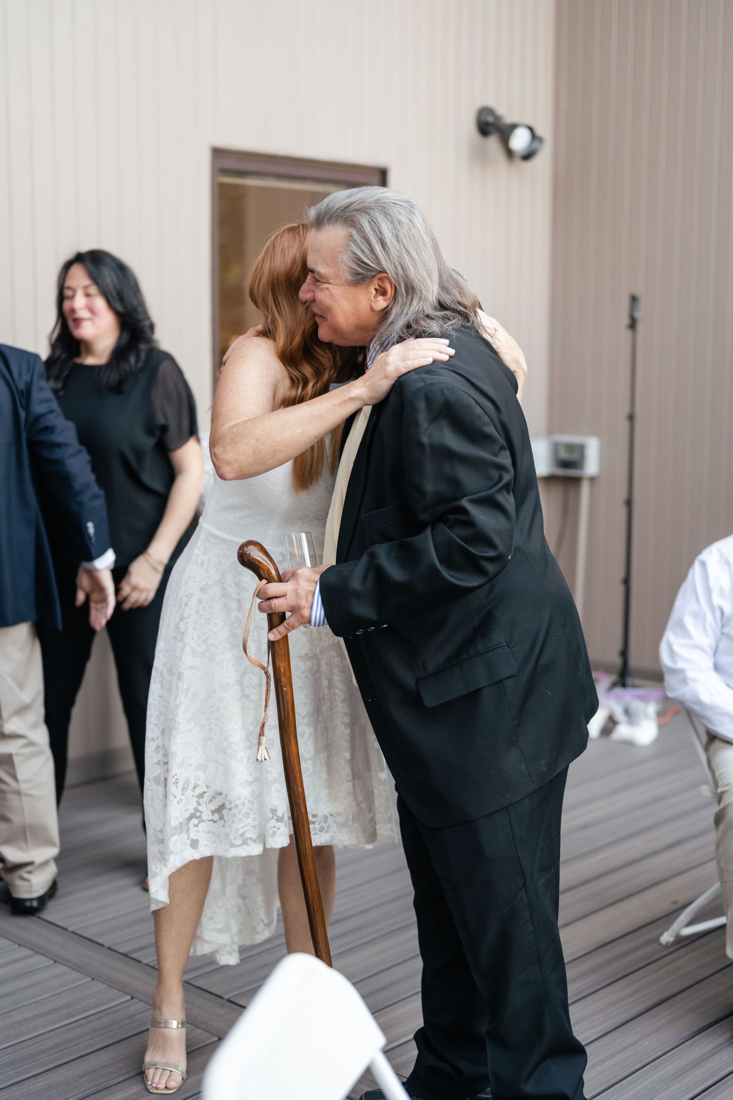 A sequence of emotional moments showing people embracing on a wooden deck during what appears to be a special occasion.