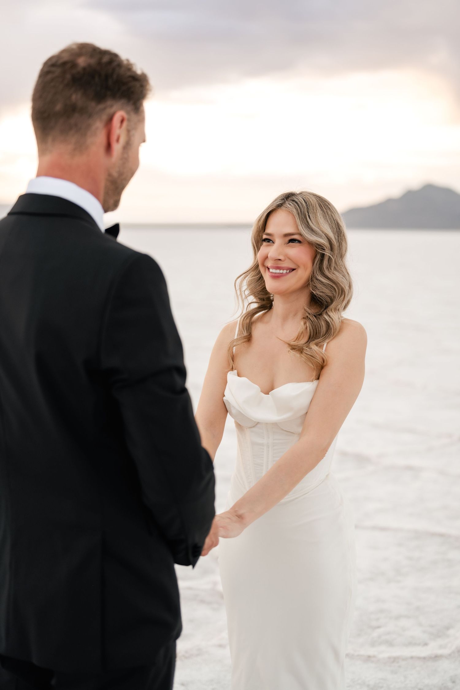 Salt Flats Elopement Photographer. A couple shares playful moments during their wedding photoshoot on a bright white landscape.