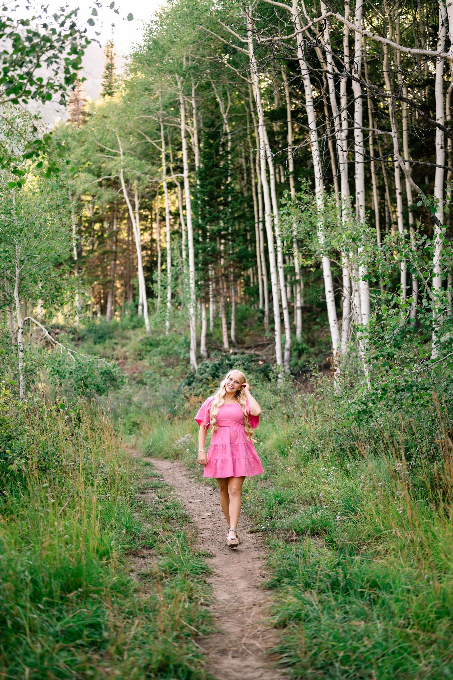 senior girl walking down the hiking path during her mountain senior session in utah