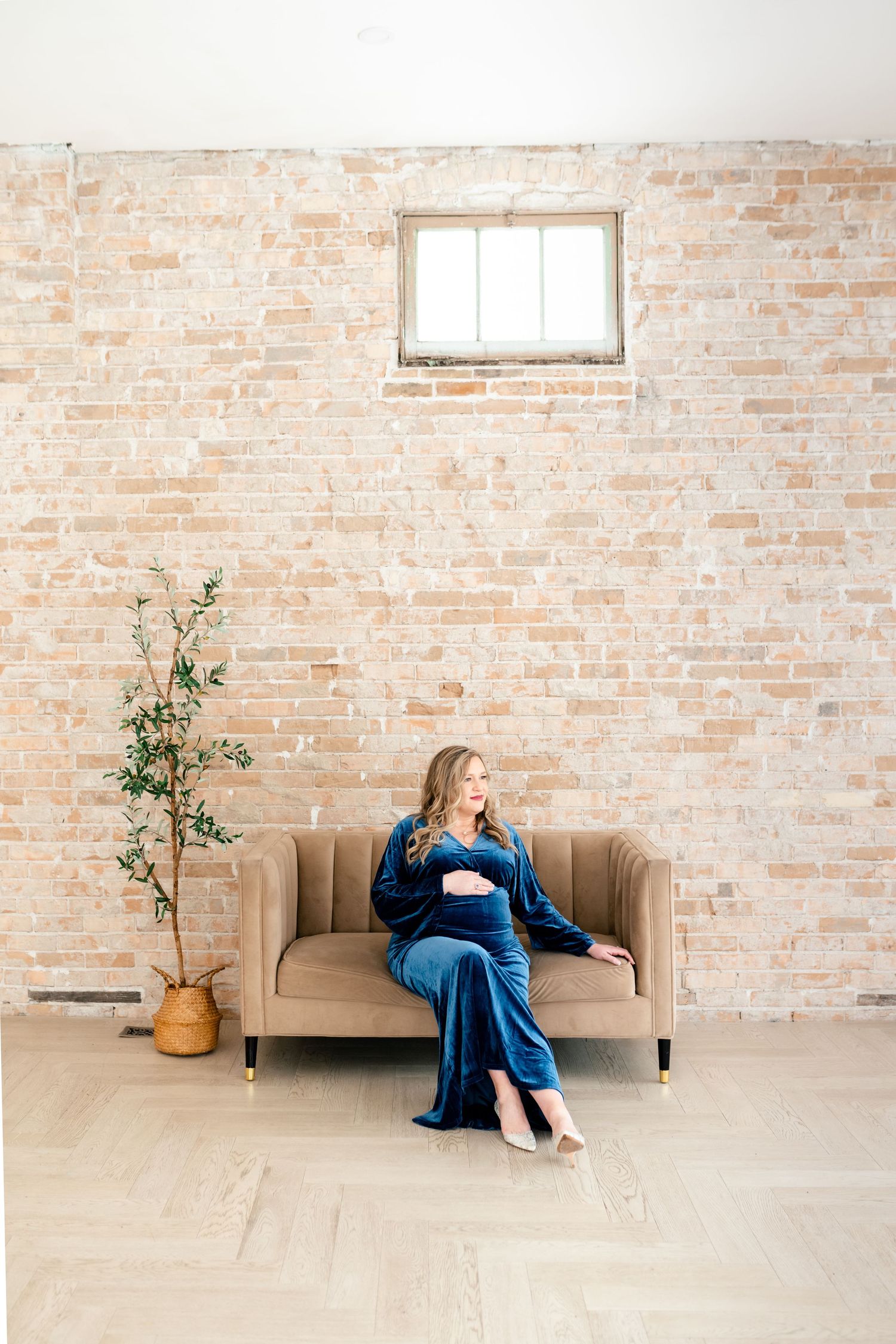 Four sequential photos showing someone in blue dress sitting on a beige couch against an exposed brick wall.
