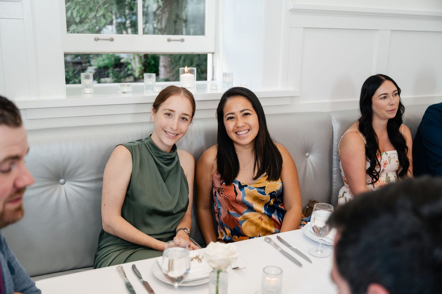 Wedding reception guests enjoying conversation at elegant dining tables.