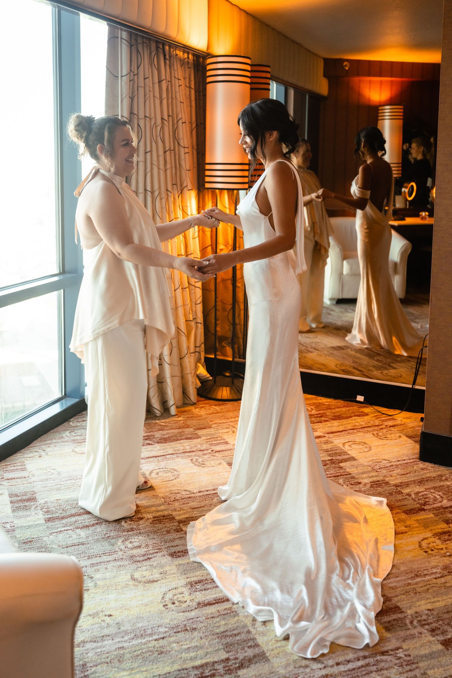 A sequence of dance movements in a warmly lit hotel hallway showing flowing white dresses in motion.