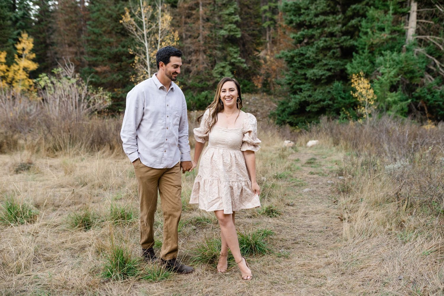 Family holding hands and walking together in American Fork Canyon for their fall family photos