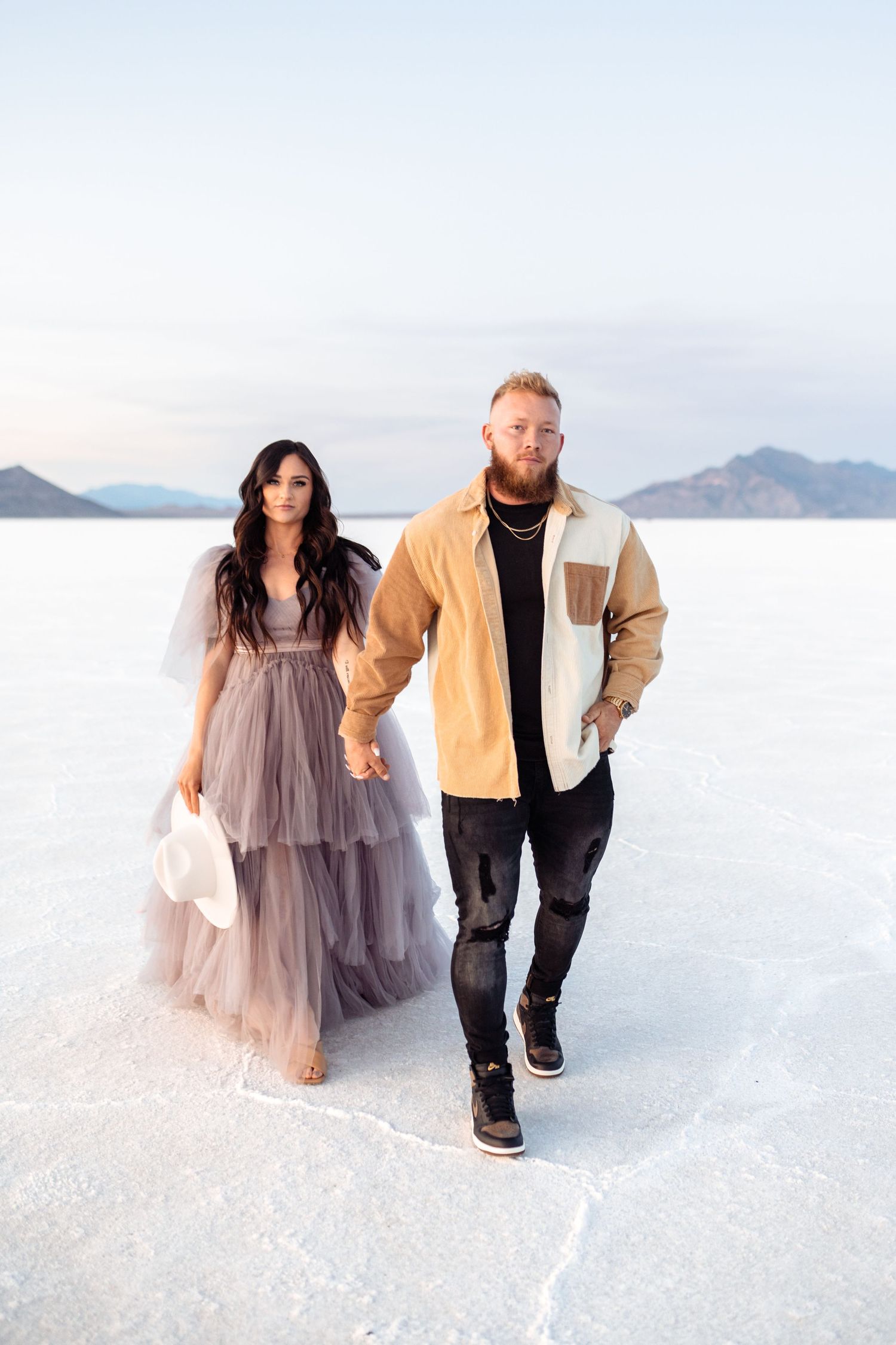 Couple holds hands during golden hour at the Salt Flats by Utah Salt Flats photographer