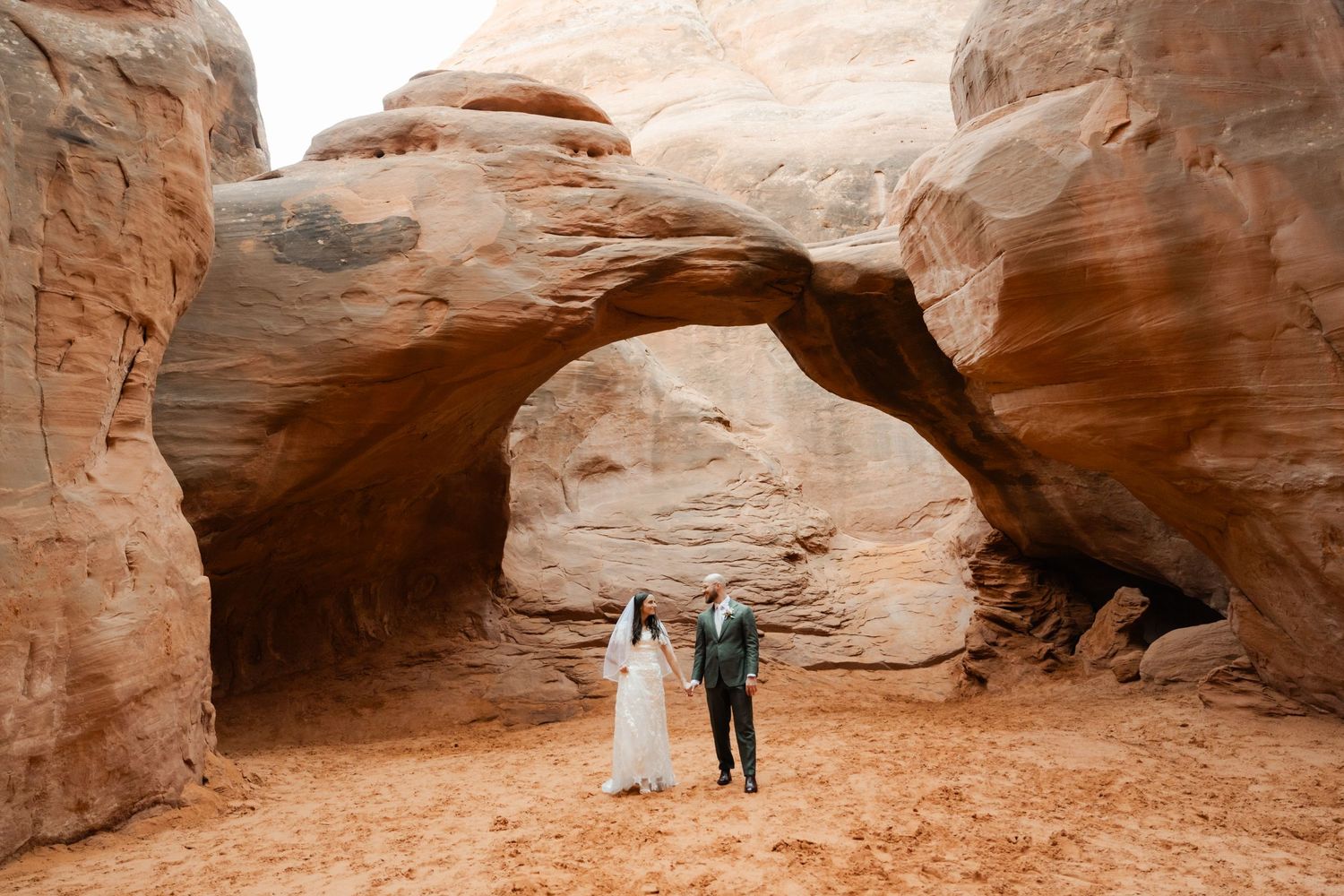 A panoramic view of red sandstone rock formations and arches in the desert landscape of Arches National Park.