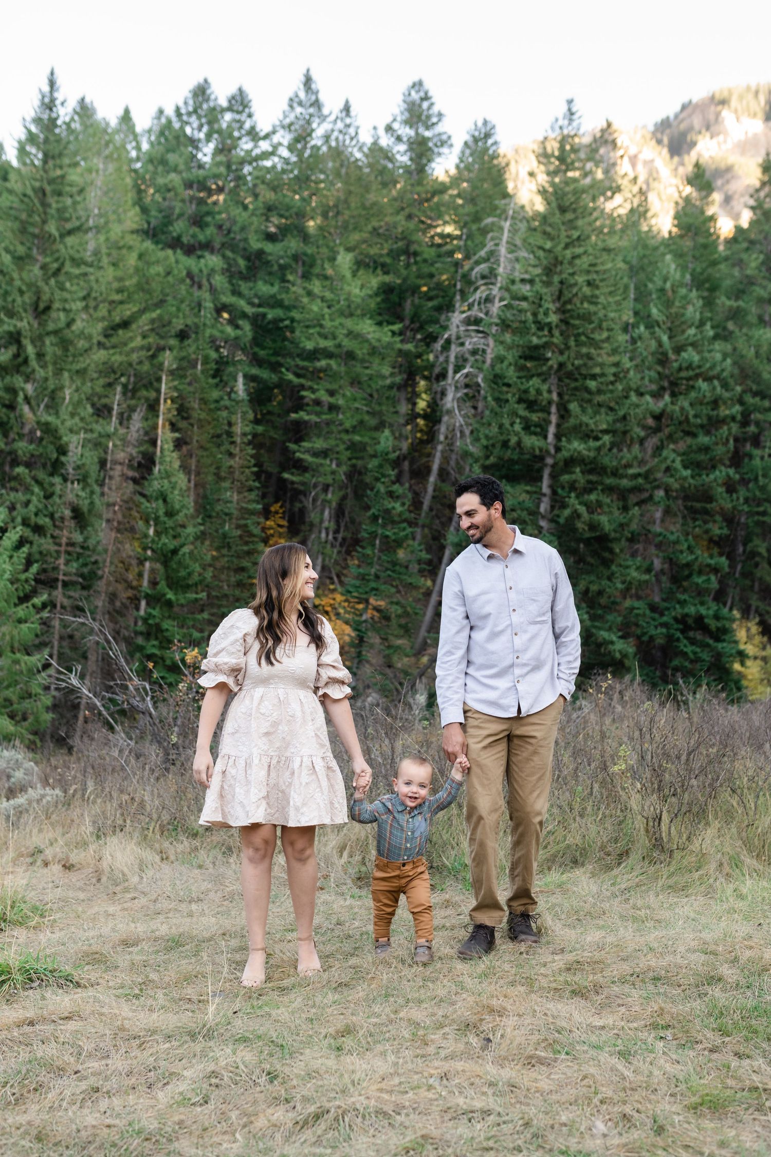 Family holding hands and walking together in American Fork Canyon for their fall family photos