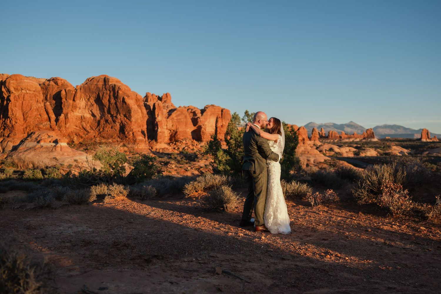 Panoramic view of red rock formations in Arches National Park at sunset.