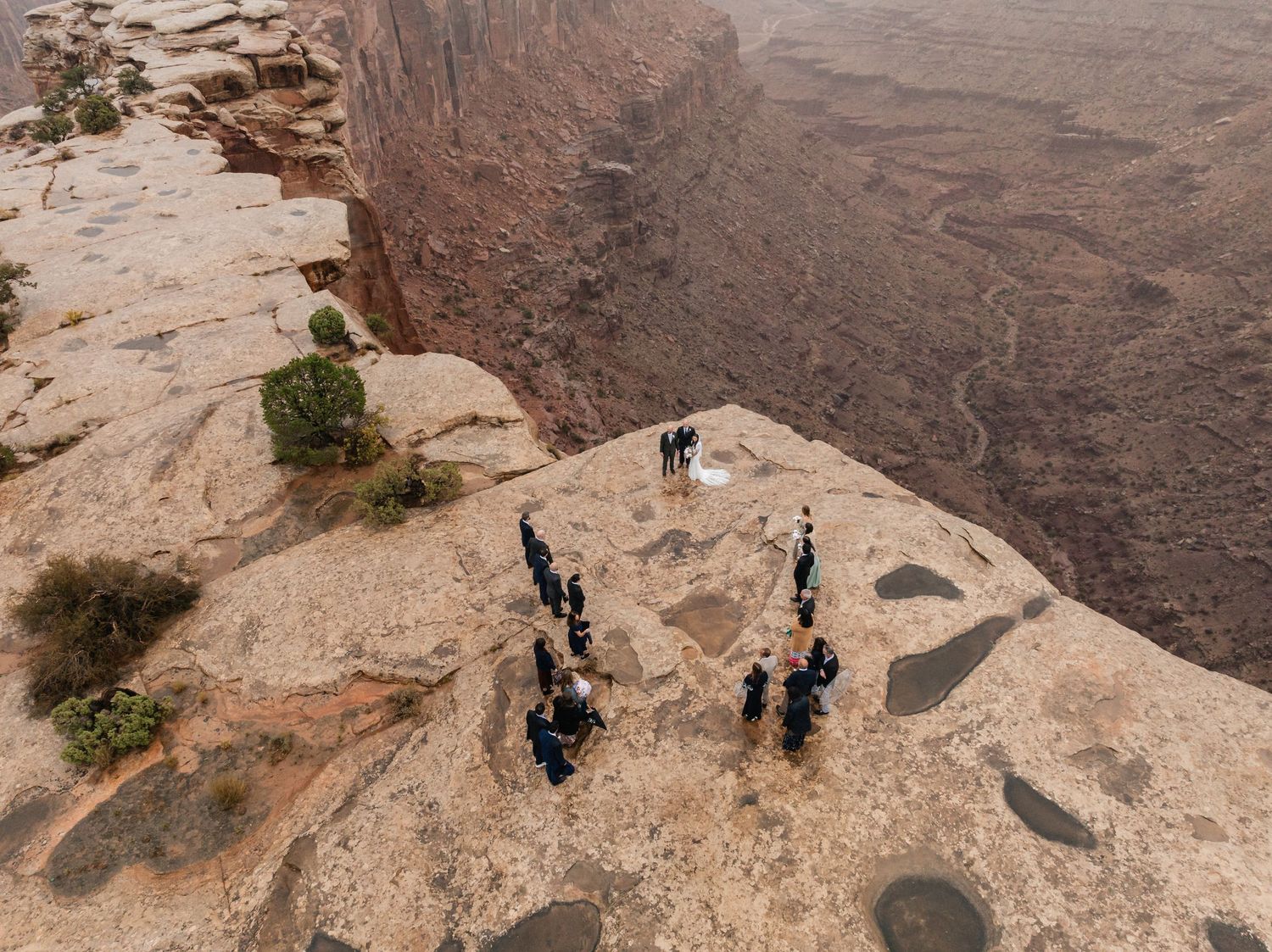 Scenic cliffside wedding ceremony overlooking dramatic desert canyons and red rock formations.