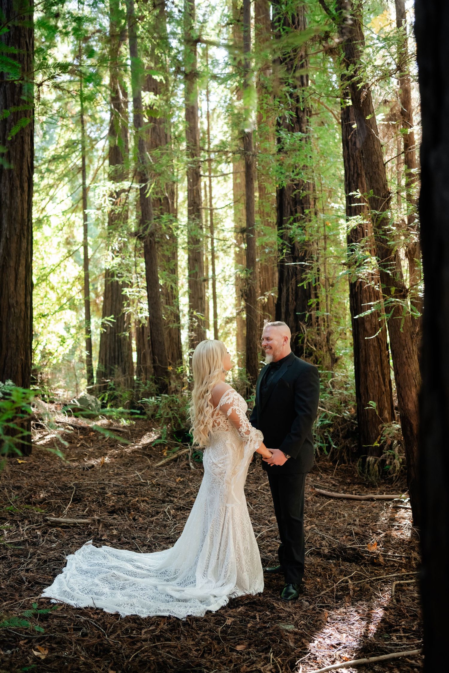 A romantic wedding moment captured in a majestic redwood forest setting.