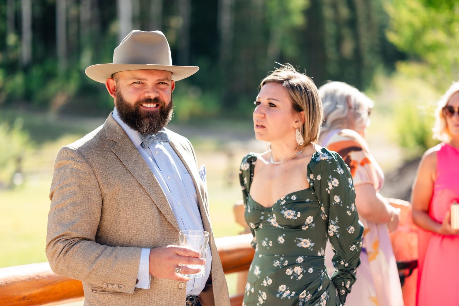 Outdoor wedding reception celebration with guests dancing and mingling in a natural setting during golden hour.
