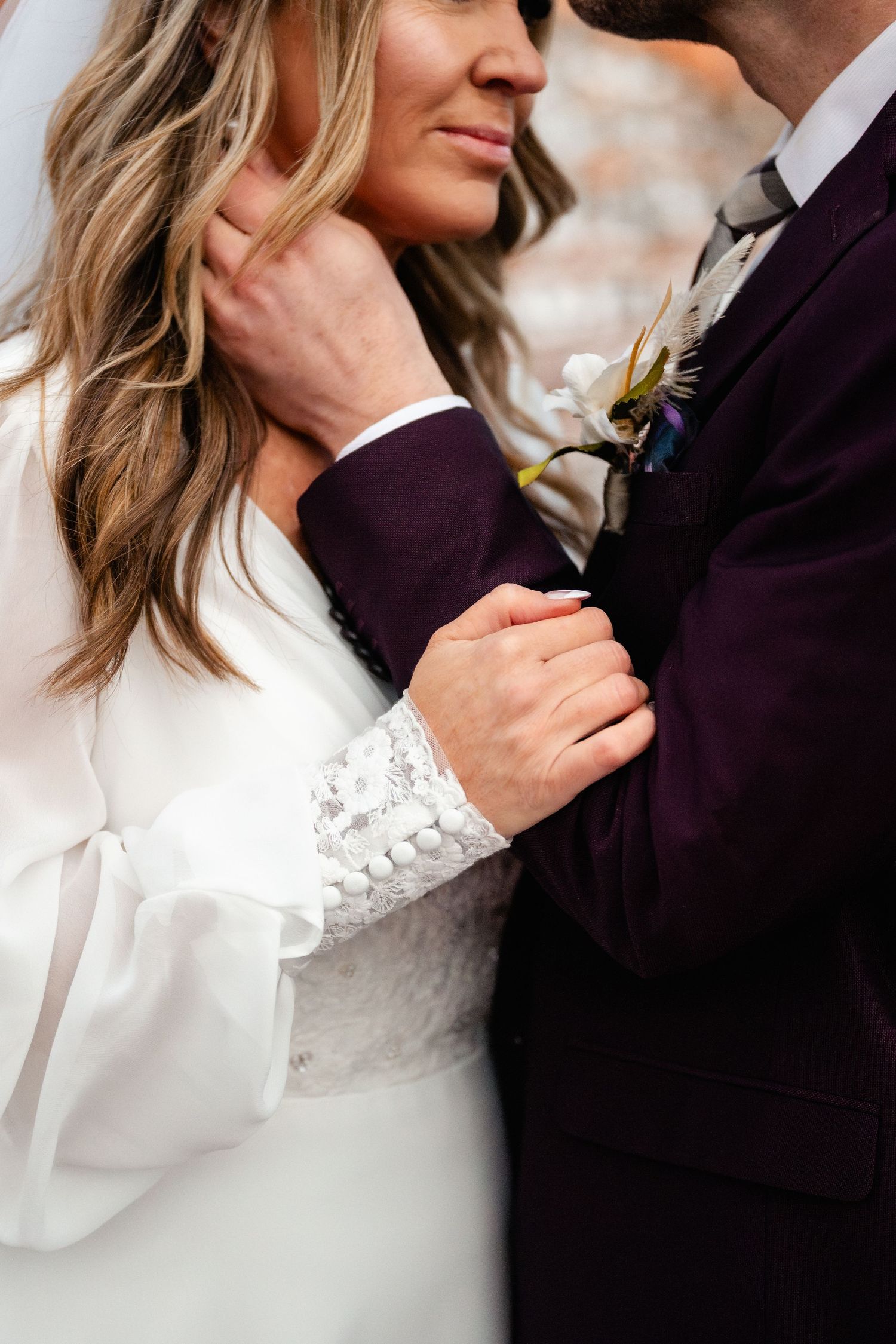 Close-up details of wedding attire showing white lace dress and purple suit.