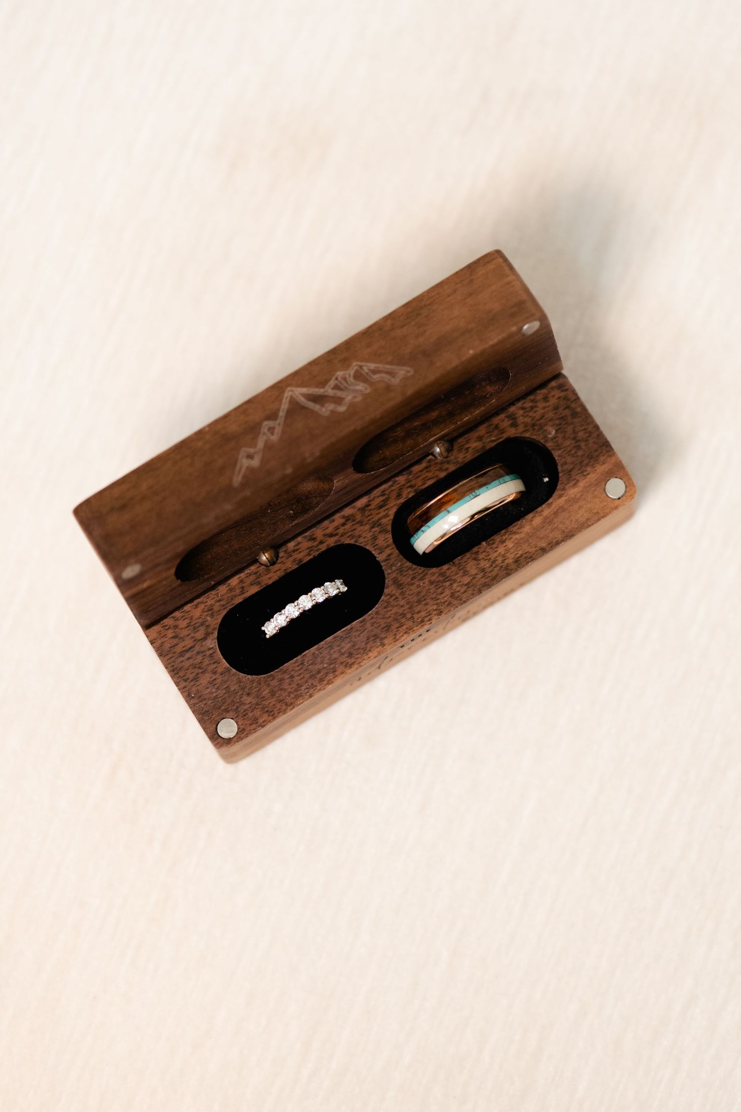 Rustic wooden phone holder with carved slot displayed on white background.