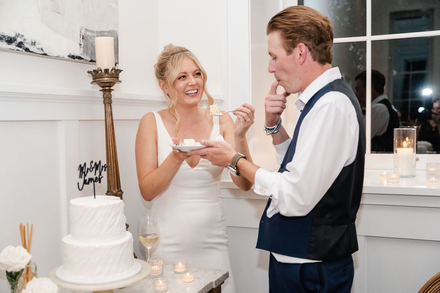 A wedding celebration unfolds with cake cutting and joyful moments in a bright indoor setting.