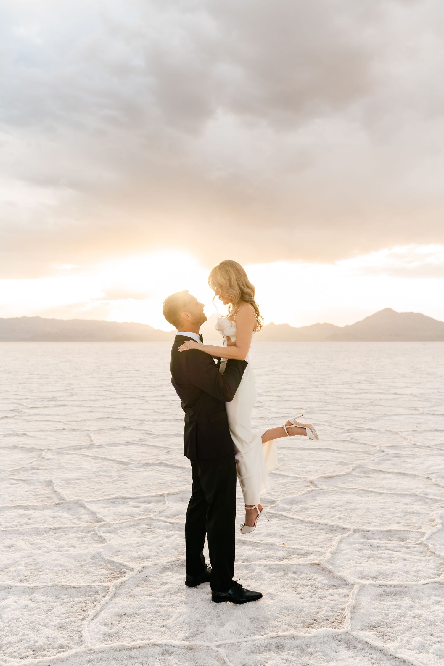 Wedding couple dancing at a cloudy sunset at the Bonneville Salt Flats. Utah Salt Flats Photographer Coley Cook.