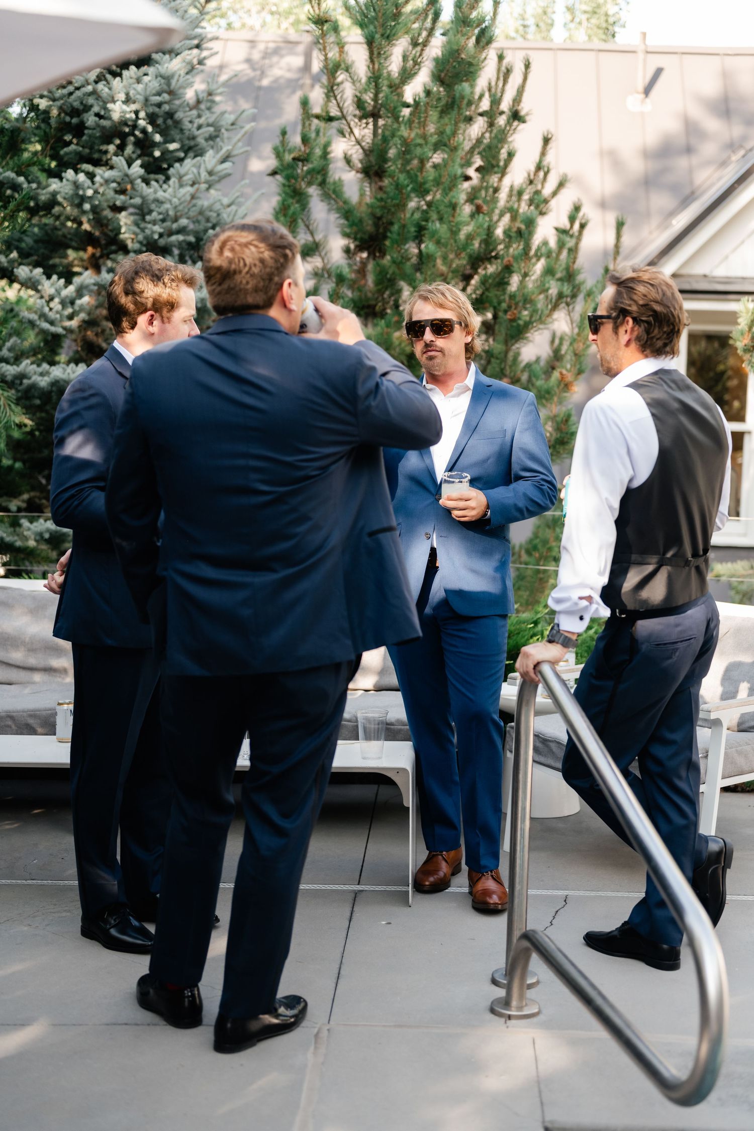 Wedding guests embracing and celebrating on an outdoor patio during reception.