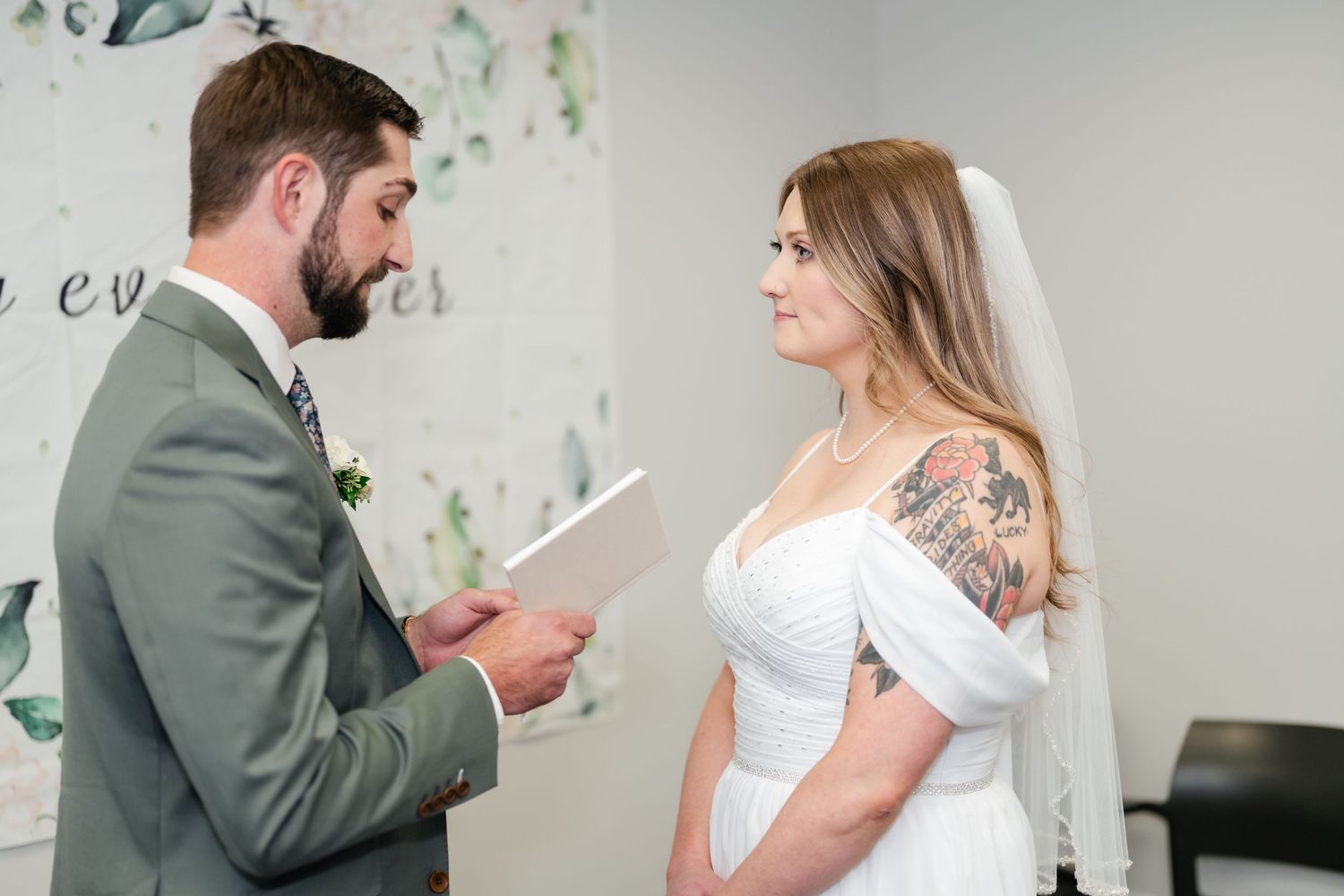 A couple shares a quiet moment in a bright room with delicate floral wall decals.