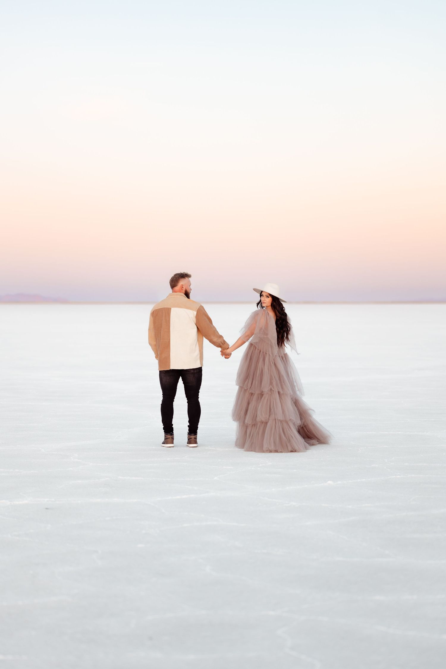 Couple holds hands during golden hour at the Salt Flats by Utah Salt Flats photographer