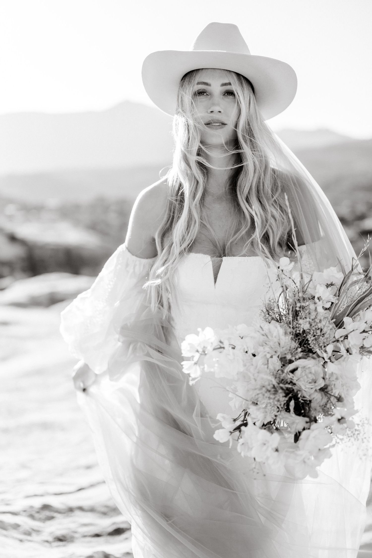 Utah elopement photographer takes breathtaking desert sunrise bridal session with a stunning bouquet and cowgirl hat.