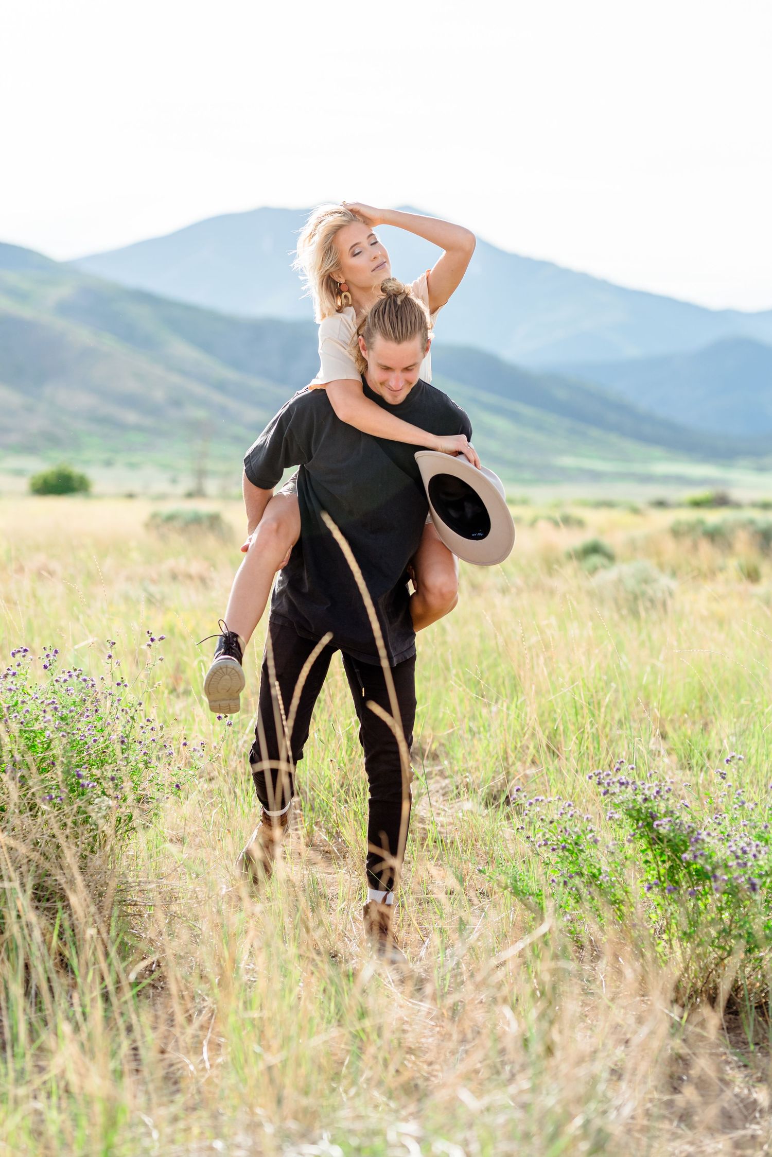 A piggyback ride through a wildflower meadow with mountains in the background.