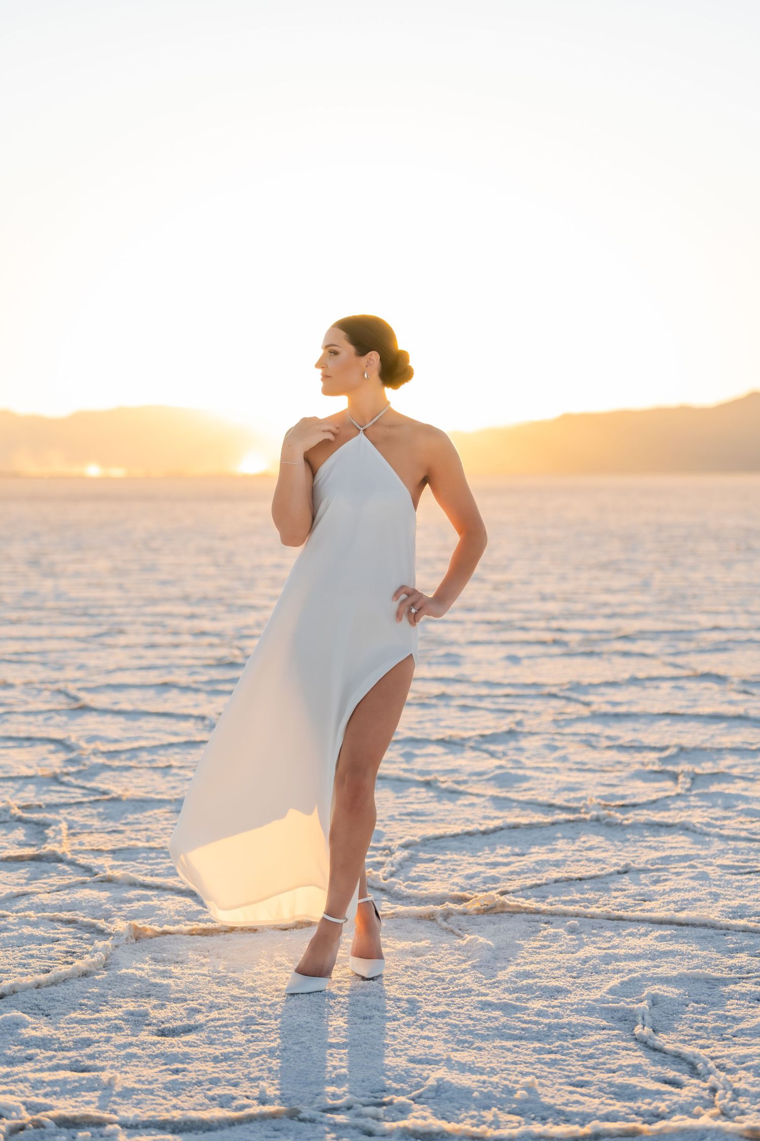 Utah Salt Flats Photographer. An artistic photo captures a dancer in white on salt flats during golden hour.