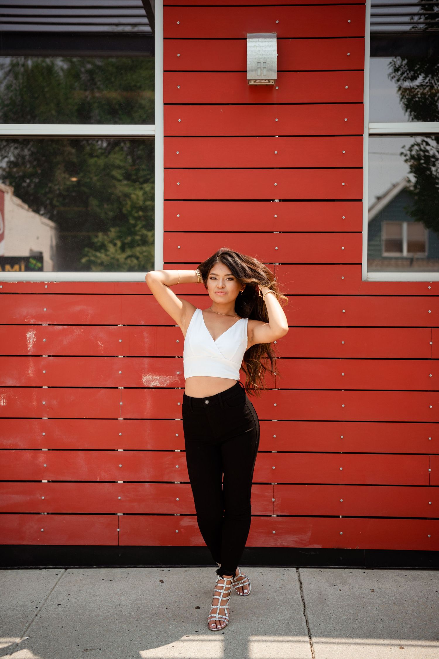 A sequence of dance poses against a red wooden wall shows graceful movement and artistic expression.