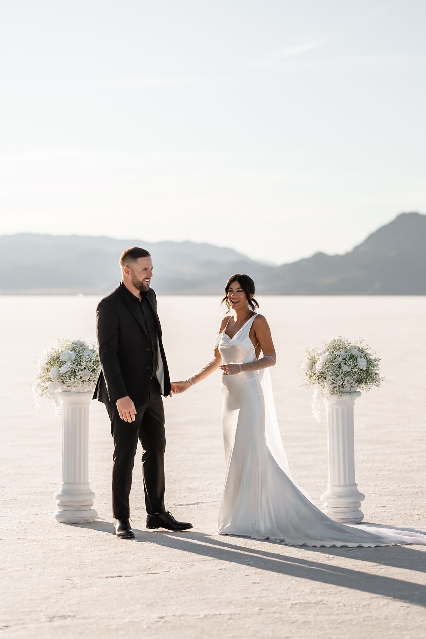 A couple in wedding attire sharing a romantic moment on the Bonneville Salt Flats.
