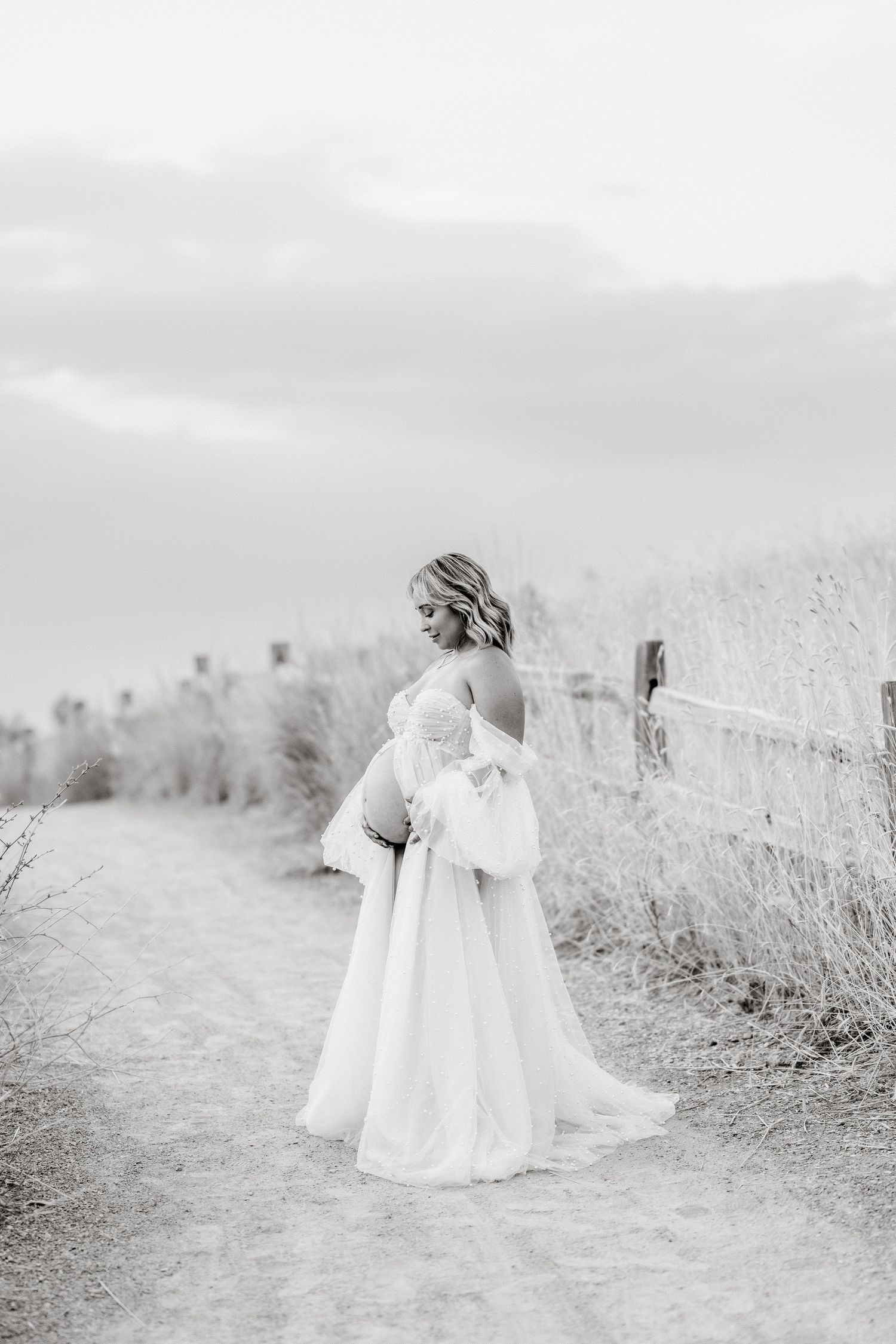 A series of black and white photos showing a child in a white dress walking along a misty outdoor path in nature.