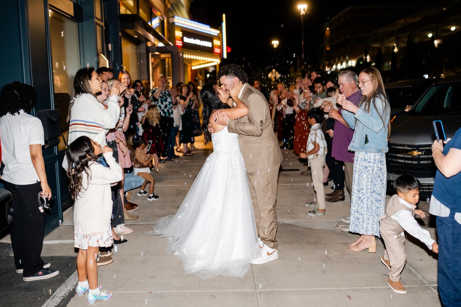 Couples dancing together on a dimly lit outdoor dance floor at a wedding reception.