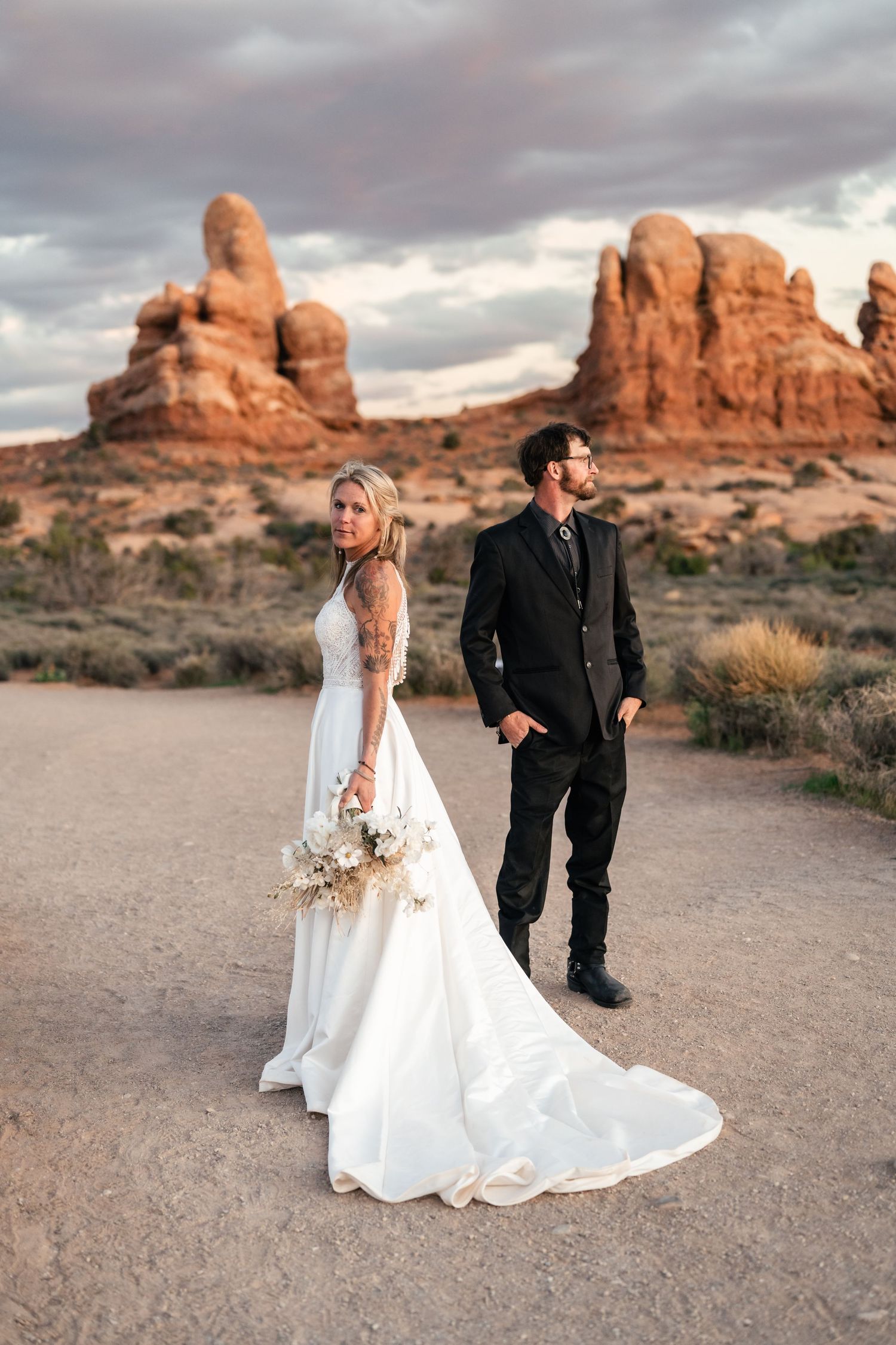 Elopement couple pose for editorial photo in Arches National Park by Utah Elopement Photographer and videographer
