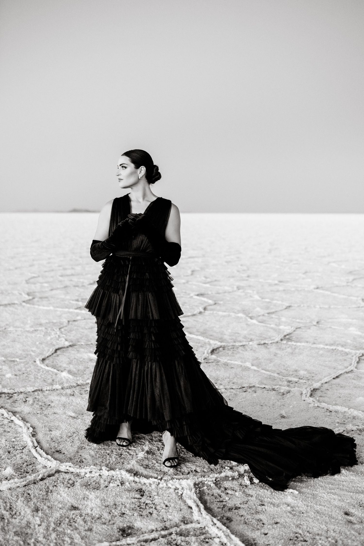 Utah Salt Flats Photographer. Dramatic black and white portrait of elegant black gown on salt flats landscape.