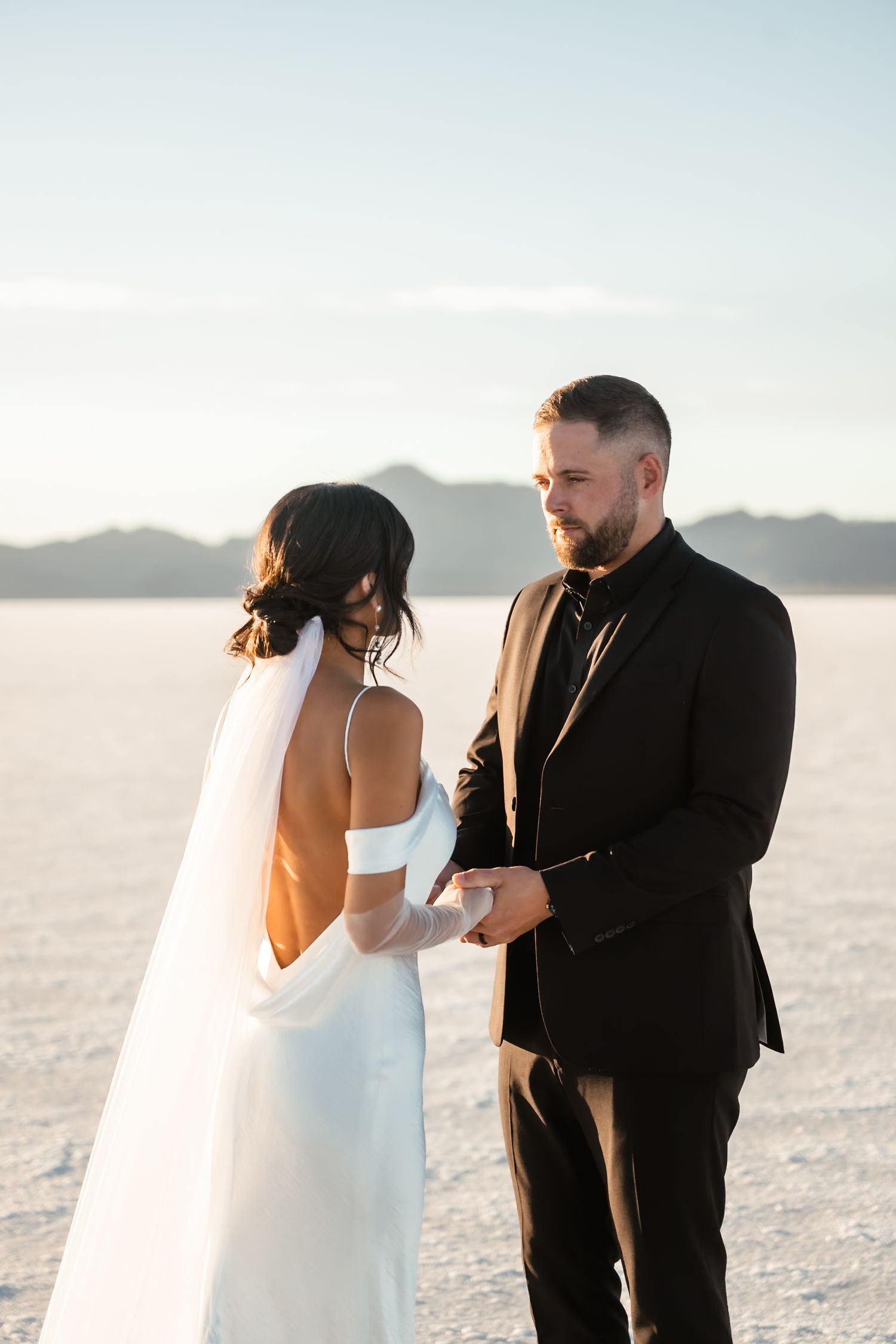 Intimate wedding couple moments captured on the bright salt flats with mountain backdrop.