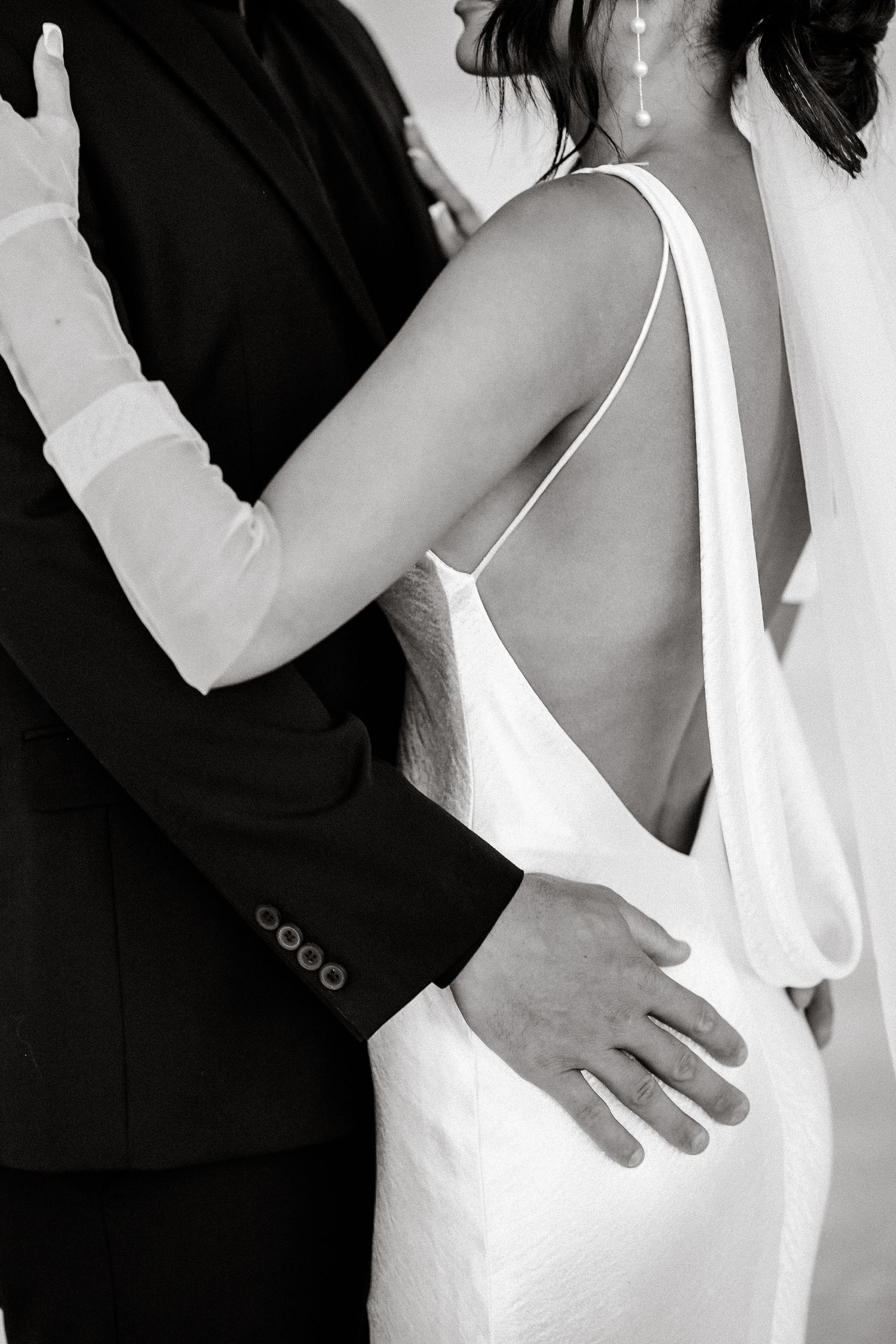 Intimate black and white photo of newlyweds embracing.