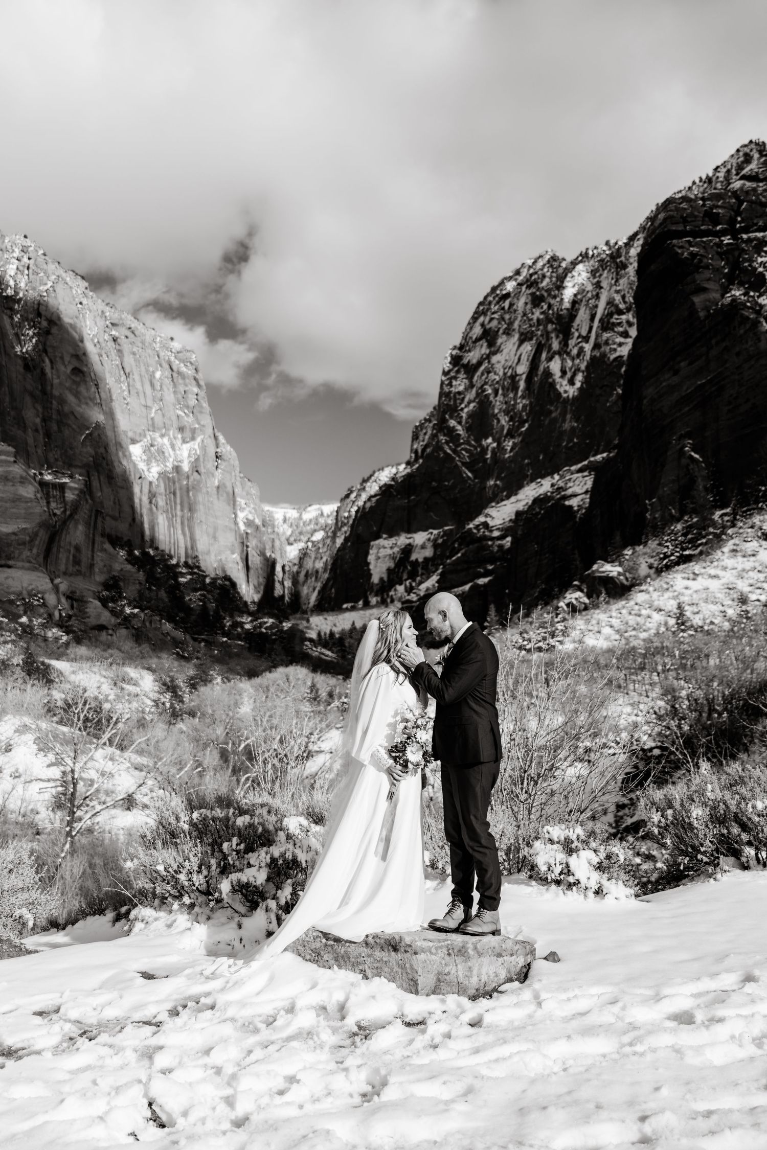 Black and white wedding photos against a snowy mountain landscape with dramatic cliffs.