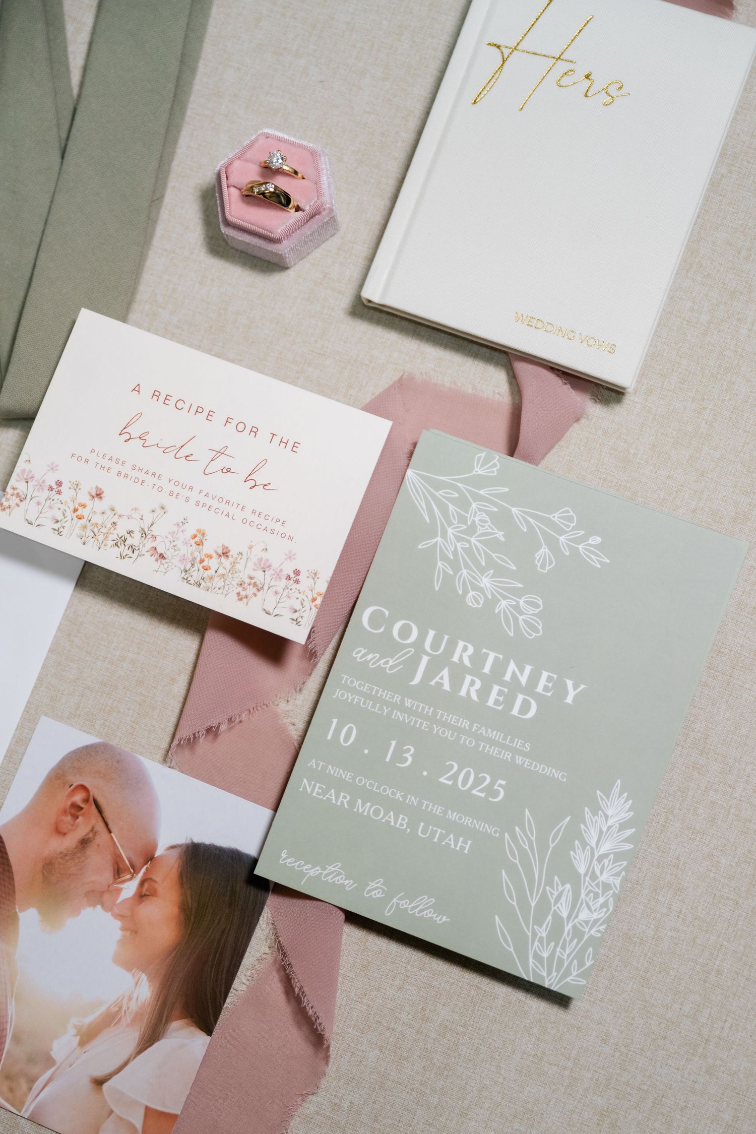 Wedding stationery suite featuring delicate floral designs in sage green and blush pink with elegant typography.